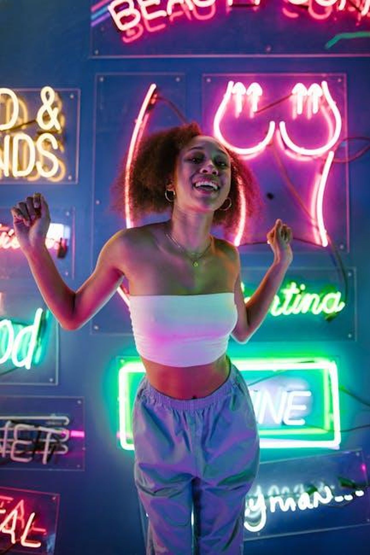 Le_recensioni_entusiaste_degli_utenti_su_TikTok_uQeh0UWwWf - Confidenze24 Source: RDNE Stock project - pexels - A young woman enjoying nightlife surrounded by colorful neon lights in a club setting.