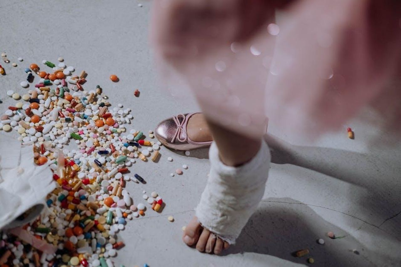 Le_rivelazioni_personali_di_Majors_cpzt4eR6Vw - Confidenze24 Source: cottonbro studio - pexels - A child's foot in a cast next to a pile of scattered pills on a white floor.
