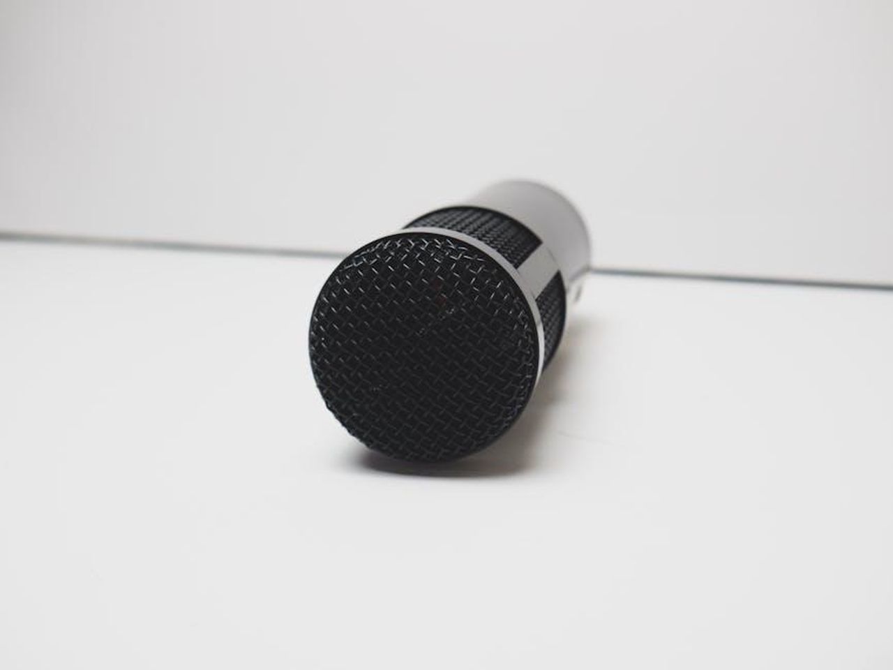 Le_sfide_della_conclusione_delle_storie_juFagGjrme - Confidenze24 Source: Stephen Audu - pexels - A detailed view of a microphone on a white background, perfect for music or broadcasting themes.