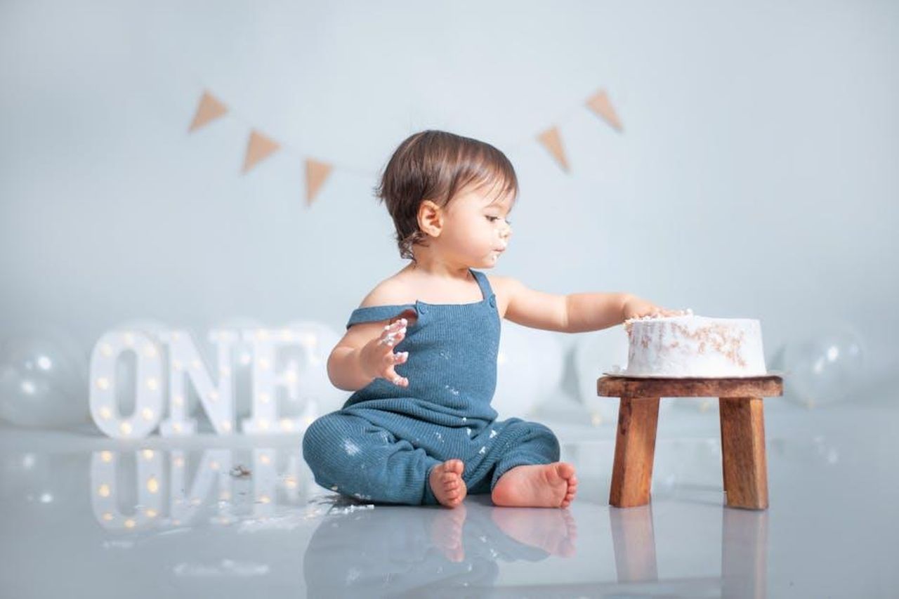 Le_sfide_di_crescere_sotto_i_riflettori_yp8pbkE5NR - Confidenze24 Source: Norman Milwood - pexels - A cute baby celebrates their first birthday with a cake smash in a pastel-themed setup.