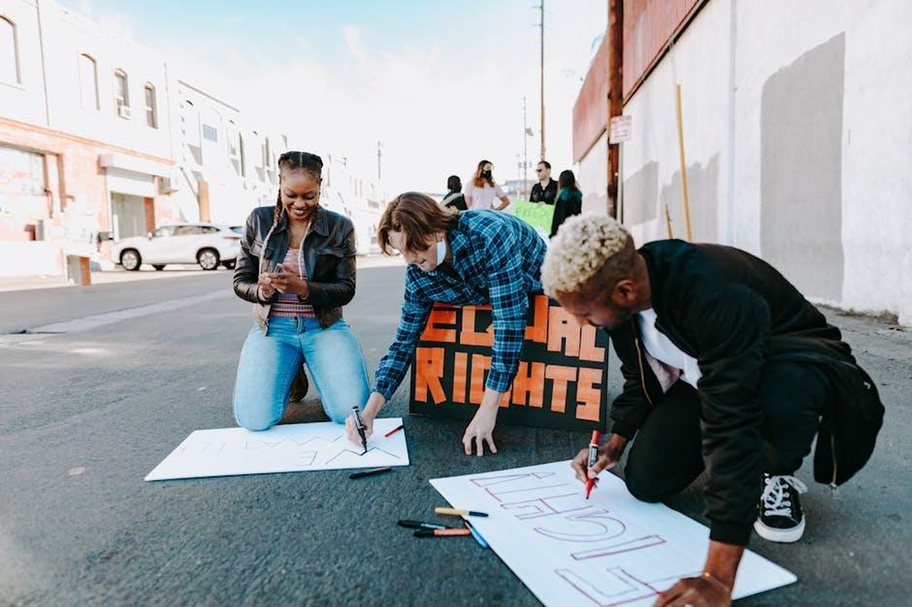 Le_speculazioni_su_una_possibile_collaborazione_OCpoXhyalp - Confidenze24 Source: RDNE Stock project - pexels - A diverse group of adults creates signs for a civil rights protest on a sunny day.