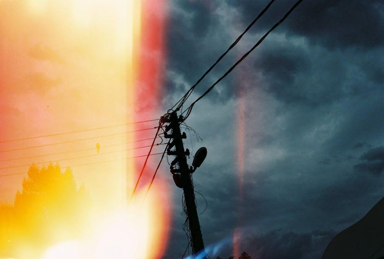 Le_tensioni_tra_Amazon_e_i_produttori_di_Bond_GUjUXbom58 - Confidenze24 Source: Yarennur BABALIK - pexels - Film image with utility pole and power lines against a dramatic sky.