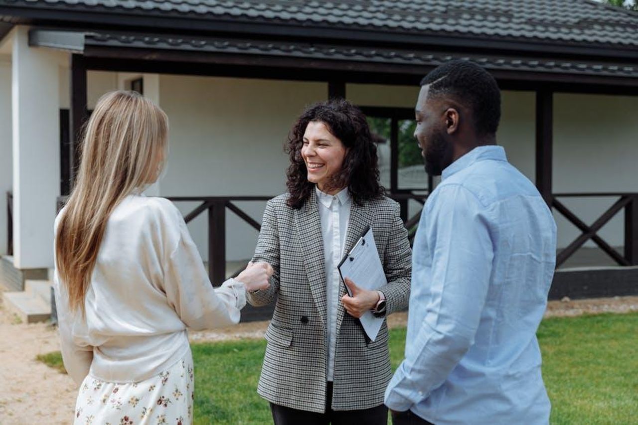 Lesito_finale_dellofferta_eMpynH1cZT - Confidenze24 Source: Thirdman - pexels - A real estate agent shakes hands with a couple outside a modern house, symbolizing a successful property deal.