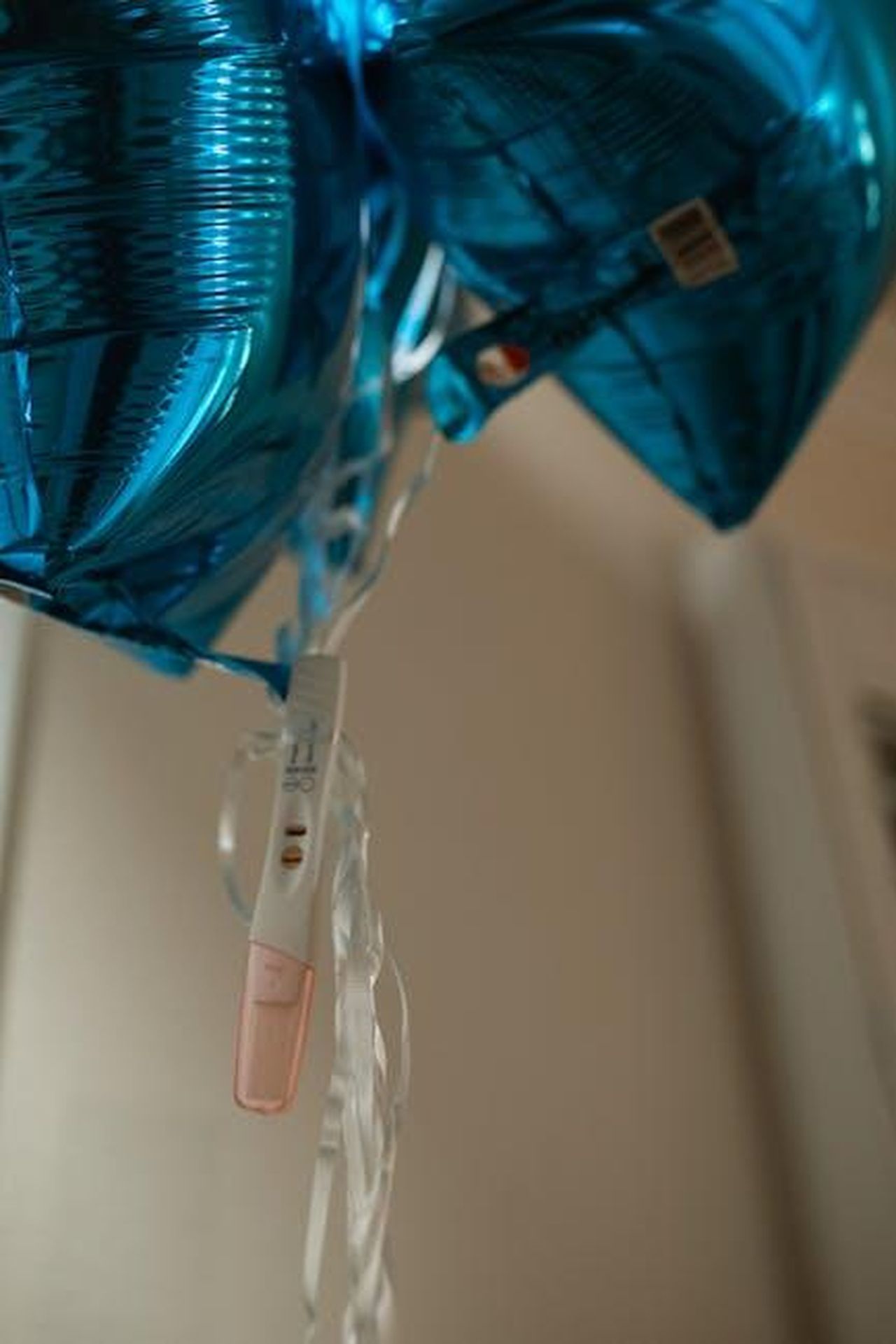 Lesperienza_di_gravidanza_di_Katharine_McPhee_BDijK4WrNr - Confidenze24 Source: RDNE Stock project - pexels - Blue balloons float alongside a positive pregnancy test, symbolizing joy and anticipation.