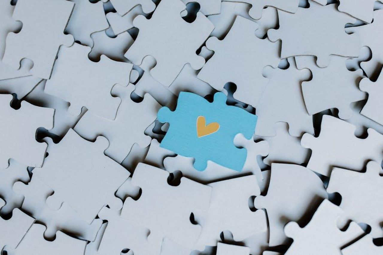 Limportanza_del_gioco_secondo_Bindi_Irwin_7Tq5UOoWVQ - Confidenze24 Source: Tara Winstead - pexels - A standout blue puzzle piece with a heart symbol among white puzzle pieces, showing uniqueness.