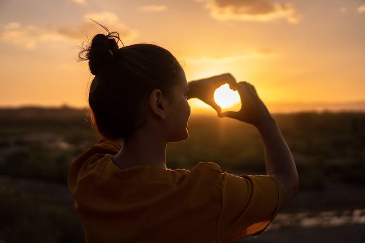 Limportanza_dellamore_per_se_stessa_nella_maternit_P8wz5J2Yct - Confidenze24 Source: Hassan OUAJBIR - pexels - A silhouette of a young woman forming a heart shape at sunset in Kelâat M'Gouna, Morocco.