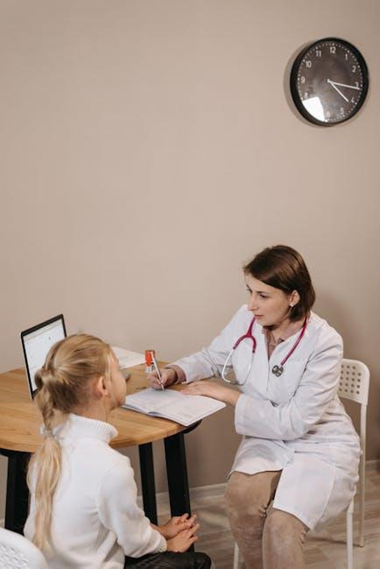 Limportanza_di_preparare_le_figlie_alla_vita_FPHqp0VfNE - Confidenze24 Source: Pavel Danilyuk - pexels - A pediatrician consults with a child in a clinic setting, focused on healthcare.