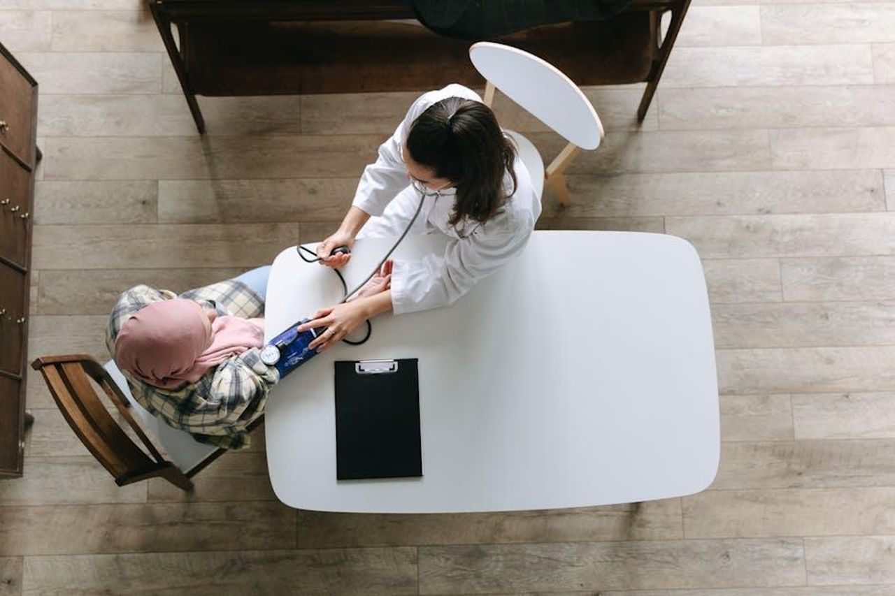 Linda_e_Anne_hanno_ricevuto_trattamenti_insieme_PSuB1IXrNn - Confidenze24 Source: Thirdman - pexels - Overhead view of a doctor checking a patient's blood pressure during a healthcare consultation indoors.