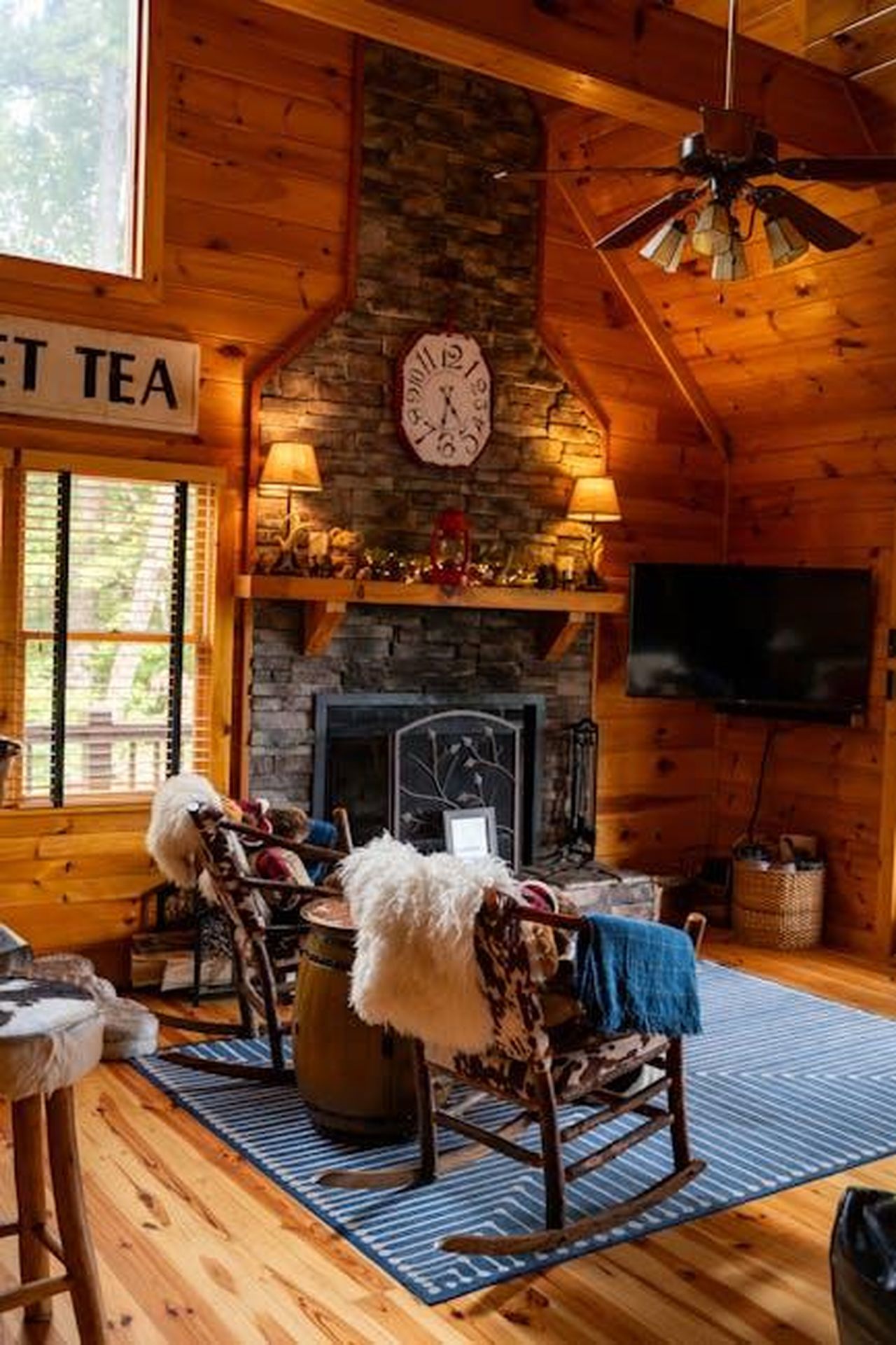 Lo_Show_Debutter_Prima_di_Quanto_Pensi_7cRQgneiEf - Confidenze24 Source: Christina Petsos - pexels - Warm rustic cabin living room featuring a stone fireplace and wooden interiors.