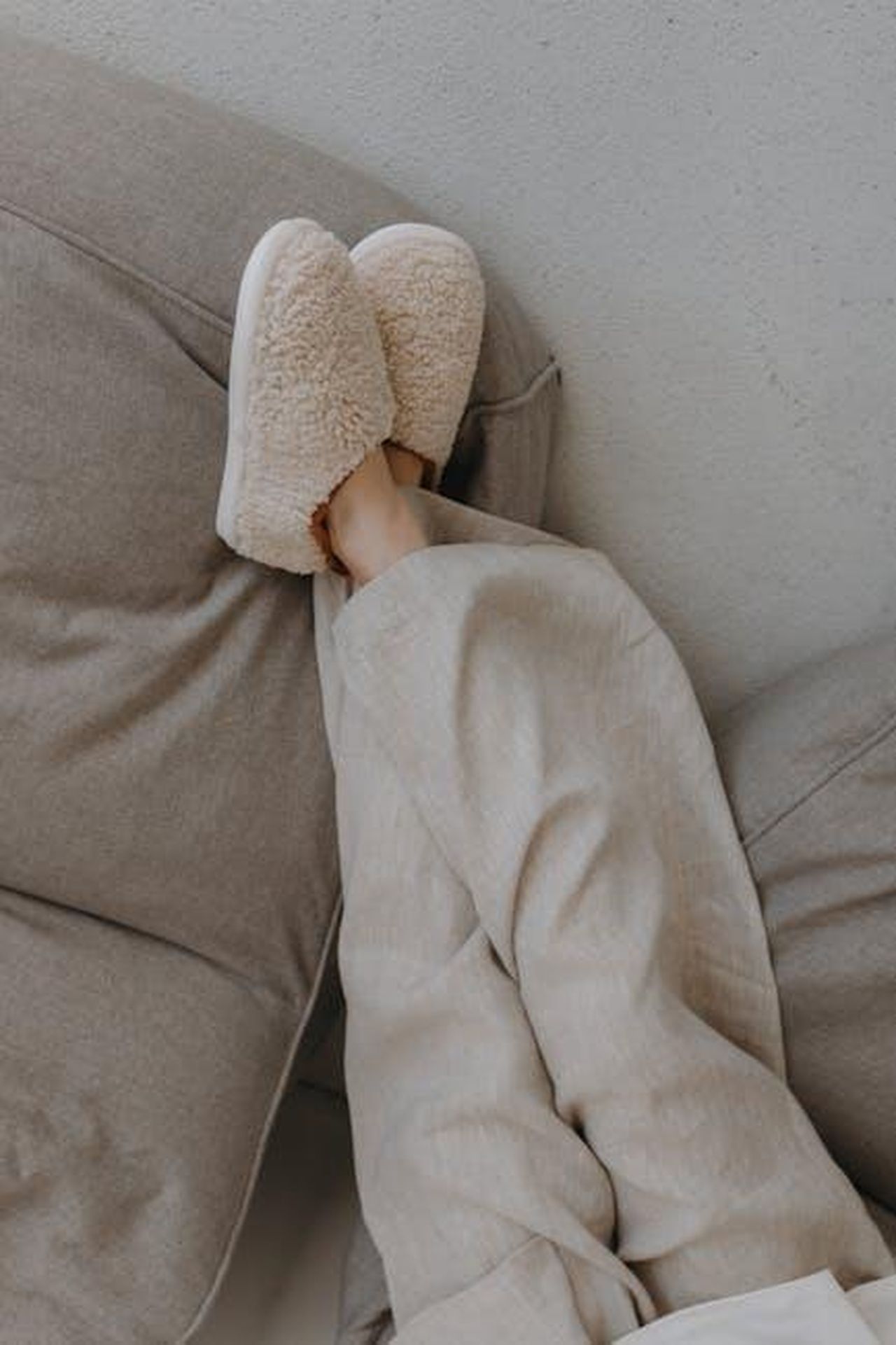 Loungewear_Spanx_Comfort_e_stile_per_la_primavera_vTT6HsVbg7 - Confidenze24 Source: Alina Matveycheva - pexels - Relaxed person lounging indoors with plush slippers, conveying warmth and comfort.