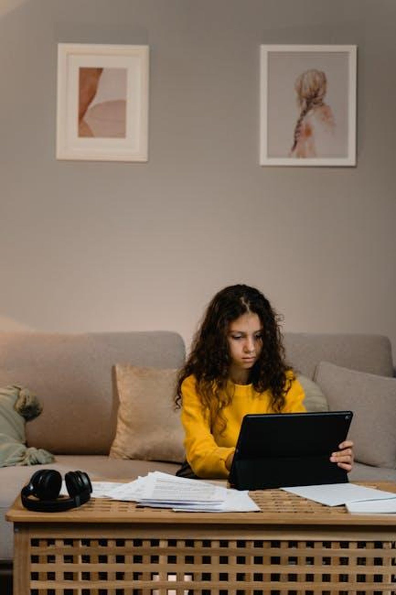 Luca_un_adolescente_talentuoso_e_appassionato_T5G18yPBT8 - Confidenze24 Source: Tima Miroshnichenko - pexels - Teen girl focused on laptop at cozy living room workspace with headphones and papers around.