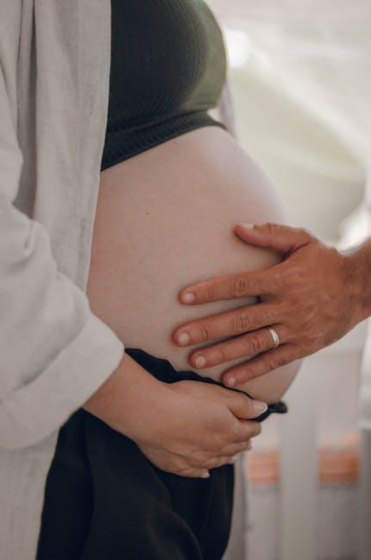 Lui_la_supporta_sempre_alGDo8AmJT - Confidenze24 Source: Vinicius Quaresma - pexels - A pregnant woman is tenderly touching her belly with a man's supportive hand.