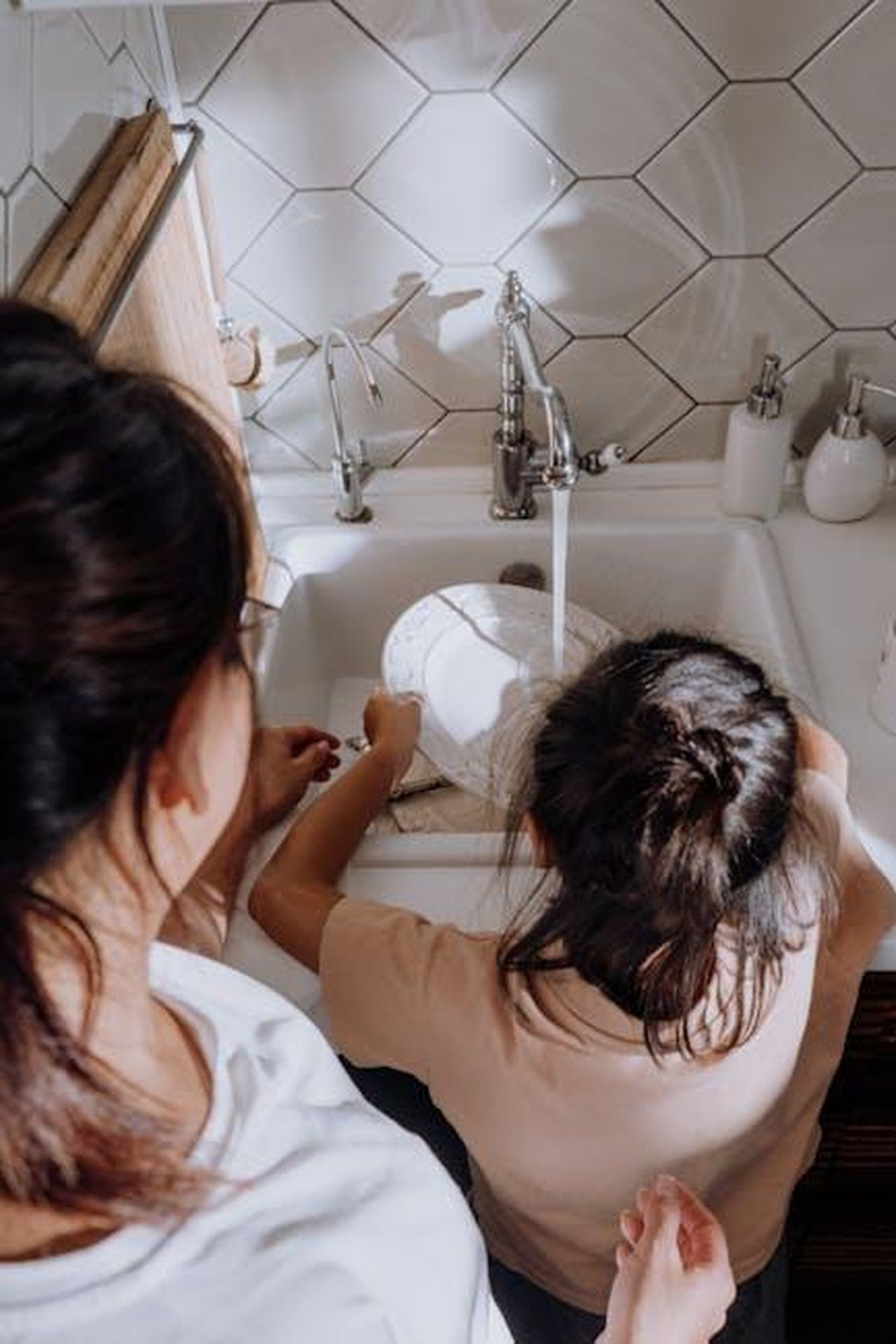Lultima_lite_tra_Vogue_e_Spencer_Y9FA2xEcJx - Confidenze24 Source: cottonbro studio - pexels - A mother teaching her child dishwashing duties at the kitchen sink.