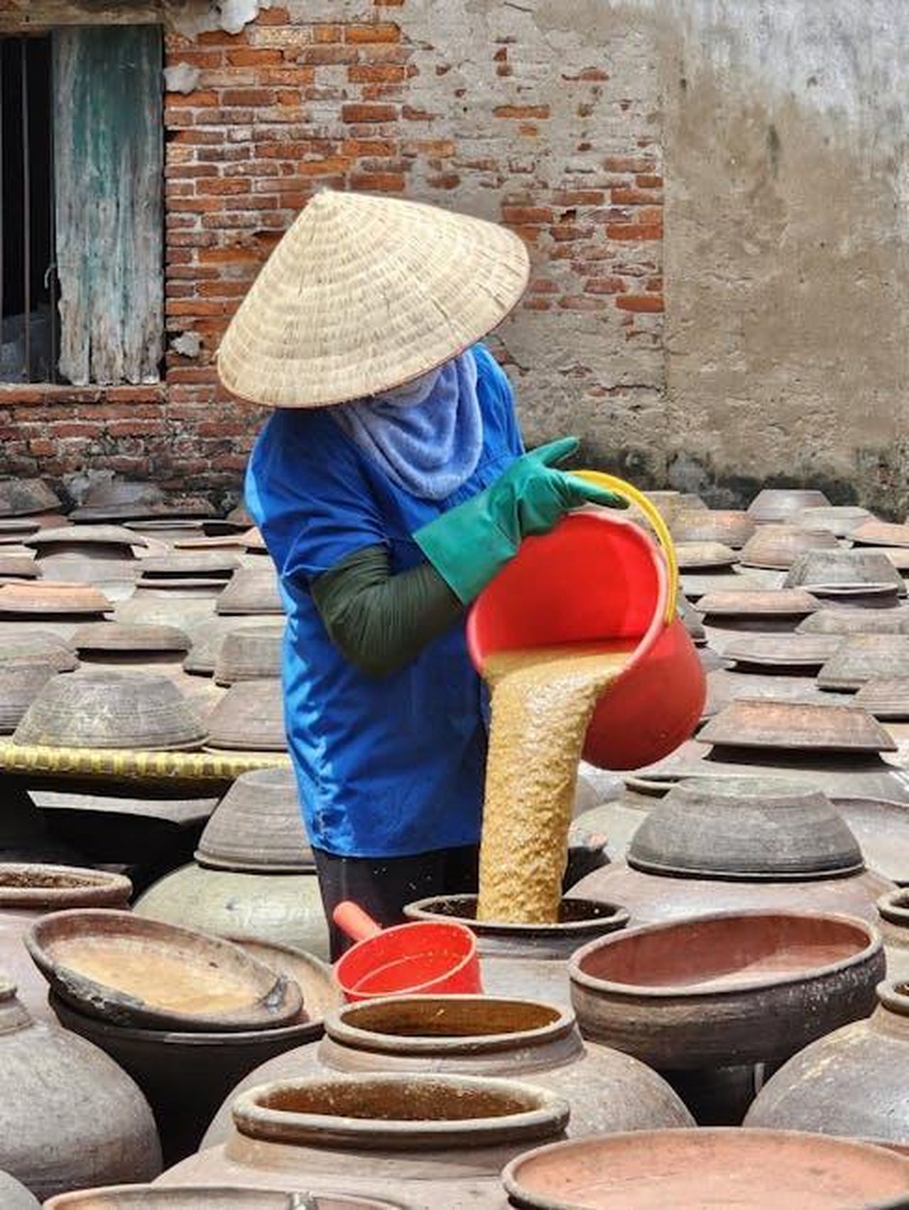 Luso_degli_oli_vegetali_nei_cibi_processati_3qDpxmzmRw - Confidenze24 Source: Duong Do - pexels - Worker pours soy mixture in pots for fermentation in a Vietnamese village.