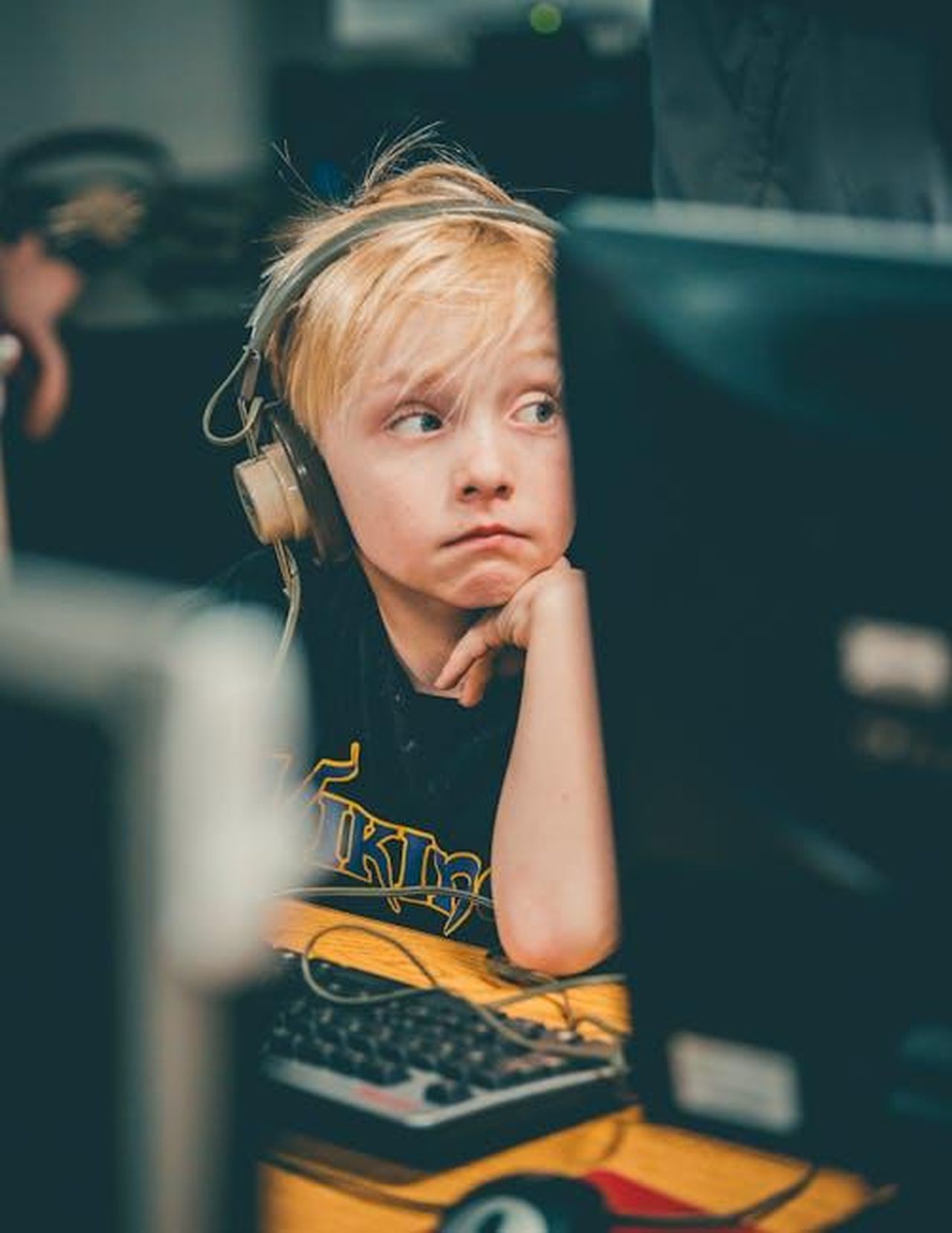 Luso_dei_dispositivi_digitali_tra_i_bambini_dqWopKZ3CX - Confidenze24 Source: Todd Trapani - pexels - Young blonde boy wearing headphones, focusing on a computer screen indoors.