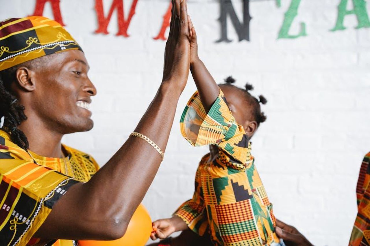 Malti__affascinata_dal_pap_gw2PXu2gdN - Confidenze24 Source: Greta Hoffman - pexels - Father and daughter share a joyful moment celebrating Kwanzaa with a high five.