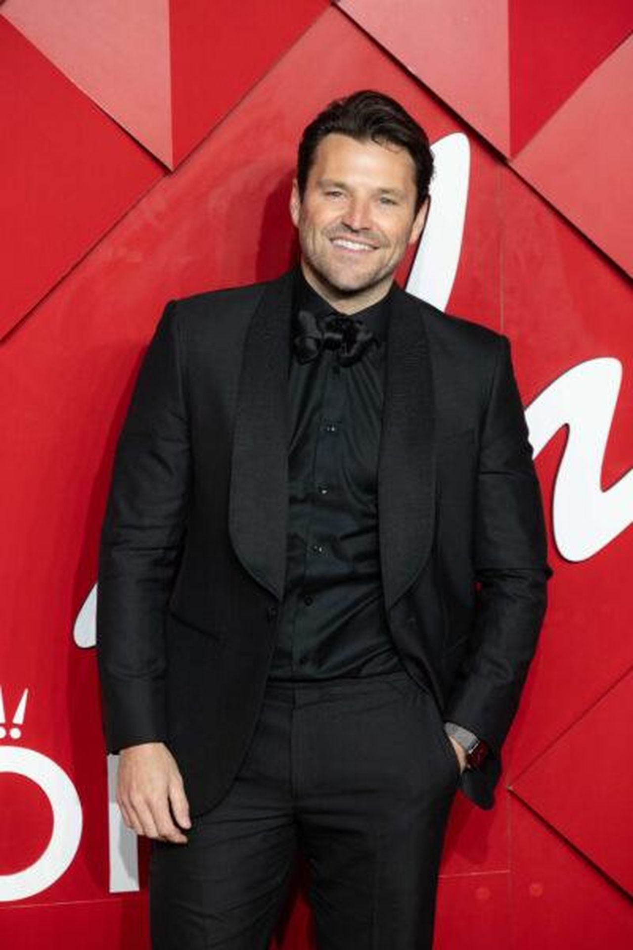 Mark_Wright_si_apre_sulla_nascita_di_Palma_al_lavoro_AzDO7dM9gr - Confidenze24 Source: Splash News - - Mark Wright sorridente contro uno sfondo rosso