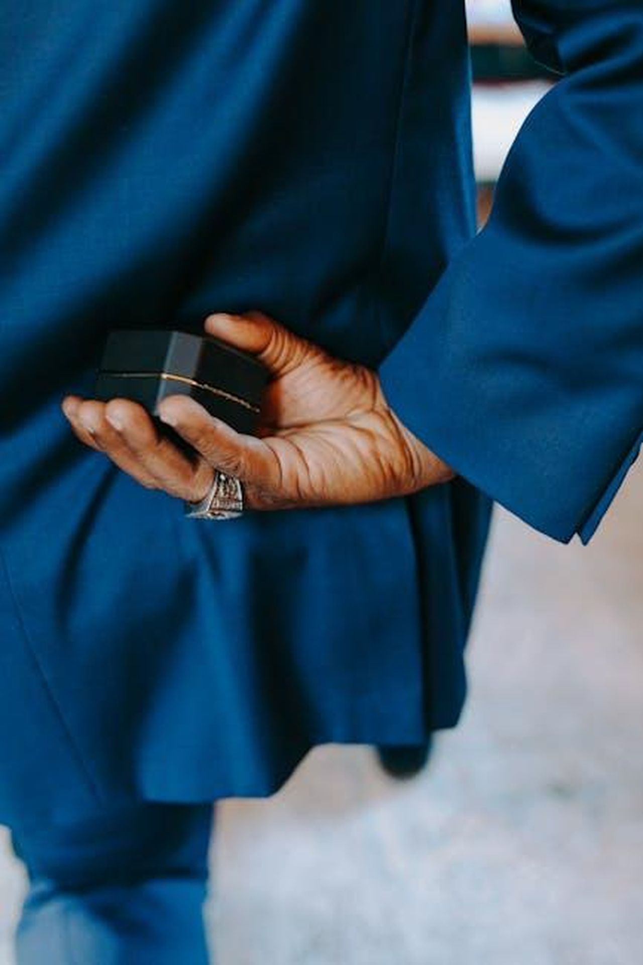 Matrimonio_reale_ZHgbzwpE0k - Confidenze24 Source: RDNE Stock project - pexels - Man in blue suit holding an engagement ring box behind his back, symbolizing a surprise proposal.