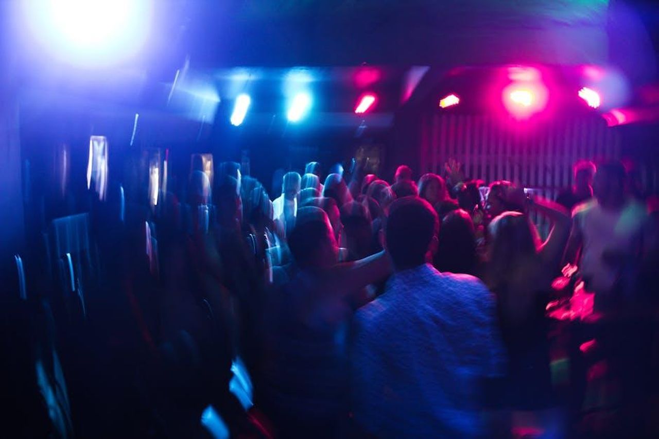 Maura_Higgins_e_Danny_Jones_hanno_festeggiato_fino_alle_6_del_mattino_tcAQx4KK84 - Confidenze24 Source: Maurício Mascaro - pexels - Vibrant nightclub scene with blurred dancing crowd and colorful lights.
