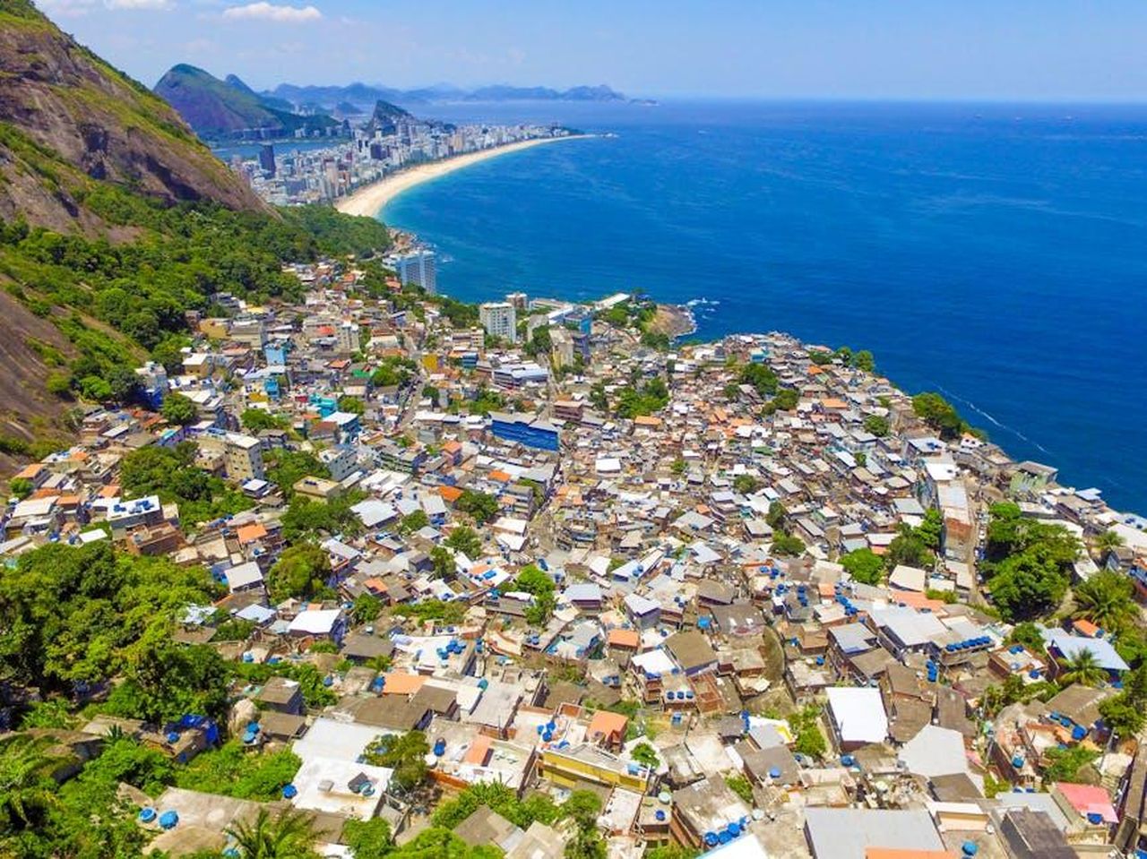 Maura_rompe_il_silenzio_FwTN01dzcr - Confidenze24 Source: Marcos Monteiro - pexels - Stunning aerial view of Rio de Janeiro's favela contrasting with the blue coastline and scenic cityscape.