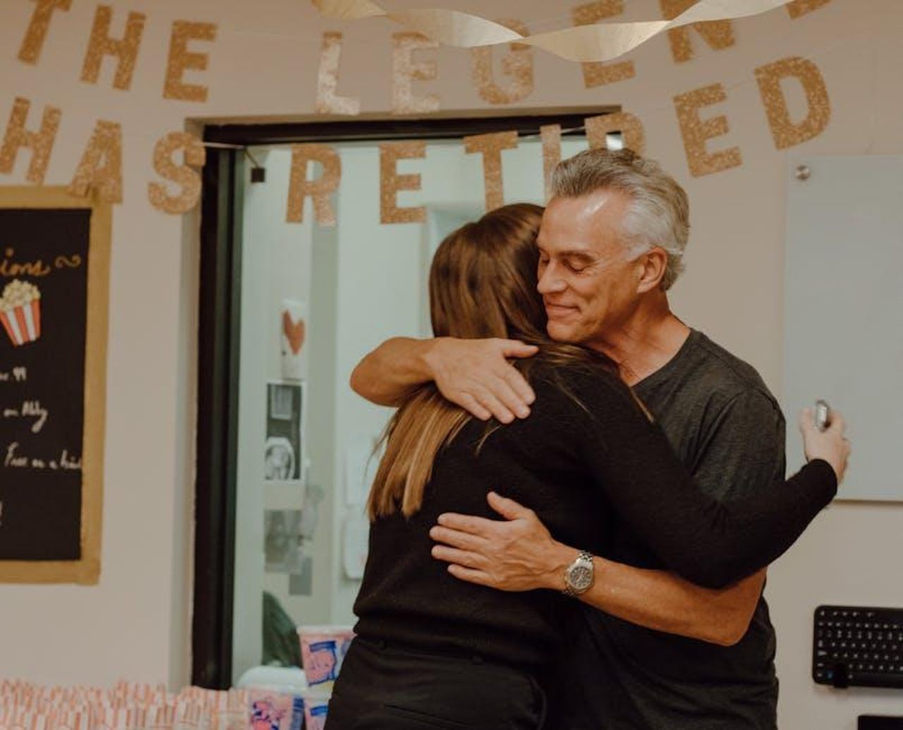 Messaggi_di_auguri_per_Dave_tDV0FhQx8F - Confidenze24 Source: Nino Sanger - pexels - A heartfelt moment as two people embrace at a retirement party with festive decor.
