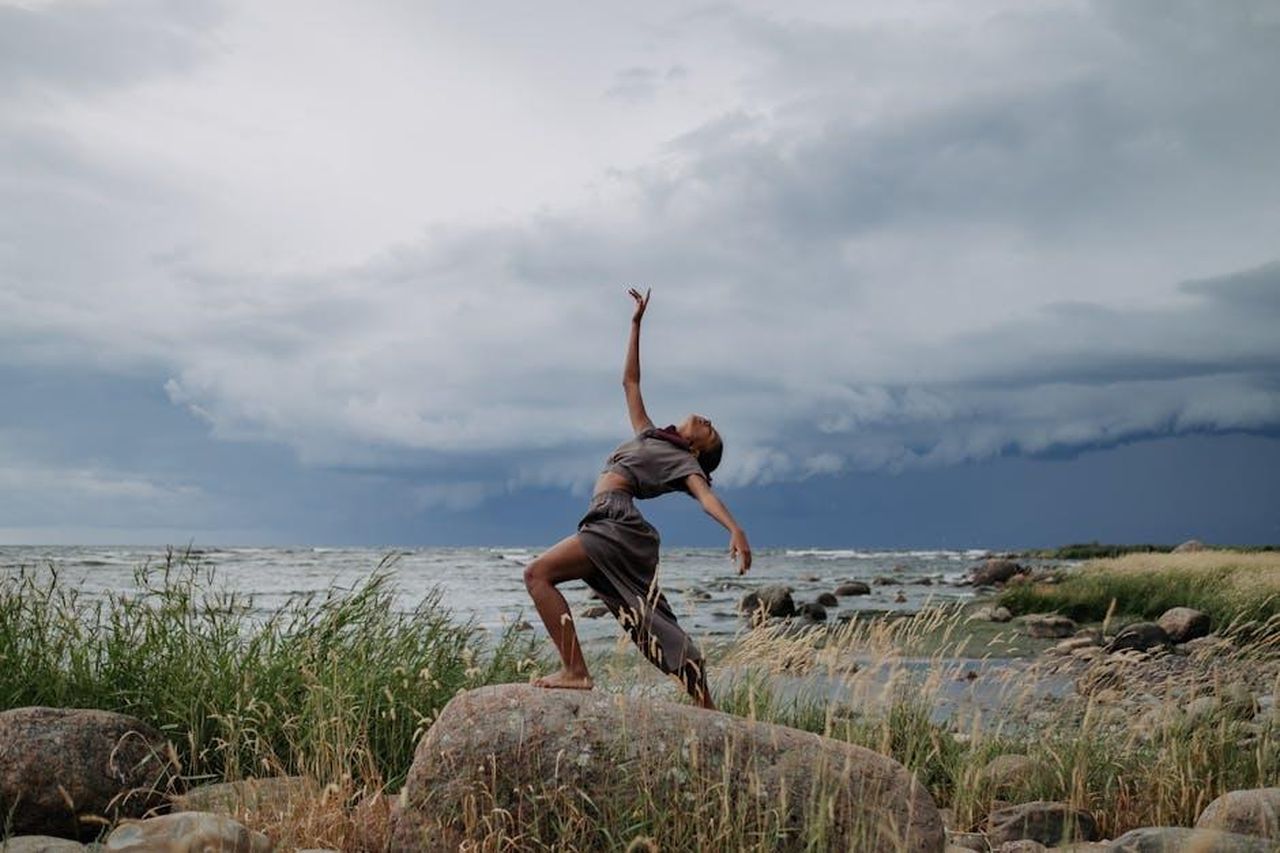 Miles_il_piccolo_performer_con_le_sue_mosse_di_danza_dGJquMmEsf - Confidenze24 Source: cottonbro studio - pexels - A woman performs a captivating dance on rocky seashore amidst dramatic storm clouds.