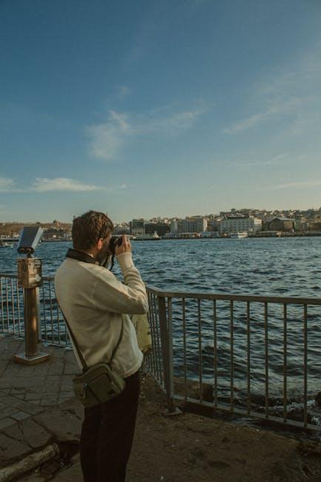 Minnie_3D_Crossbody_la_borsa_ideale_per_Disney_HKDPBD3h7y - Confidenze24 Source: Serdar Göksu - pexels - A man with a camera photographing a scenic waterfront view on a sunny day.