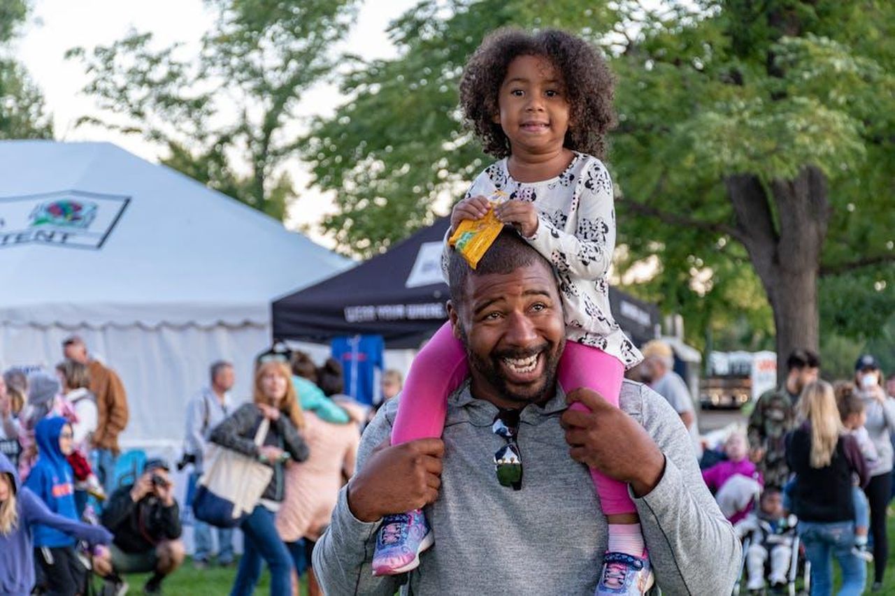 Momenti_divertenti_e_commenti_dei_fan_znF612fDIY - Confidenze24 Source: Brett Sayles - pexels - A joyful father carrying his daughter at an outdoor festival surrounded by people and tents.