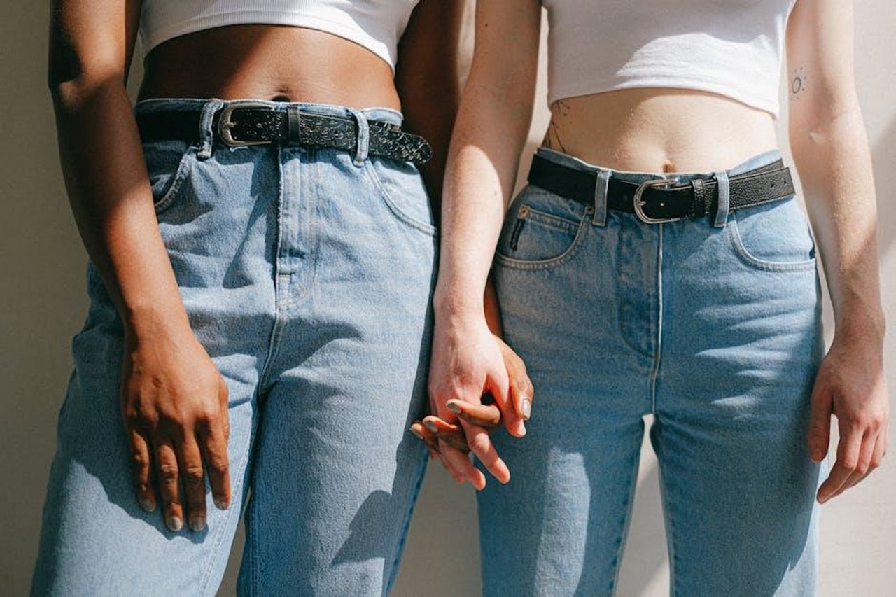 Momenti_dolci_condivisi_su_Instagram_DvYtGPaQyj - Confidenze24 Source: Anna Shvets - pexels - Close-up of interracial lesbian couple holding hands, expressing love and diversity in denim outfits.