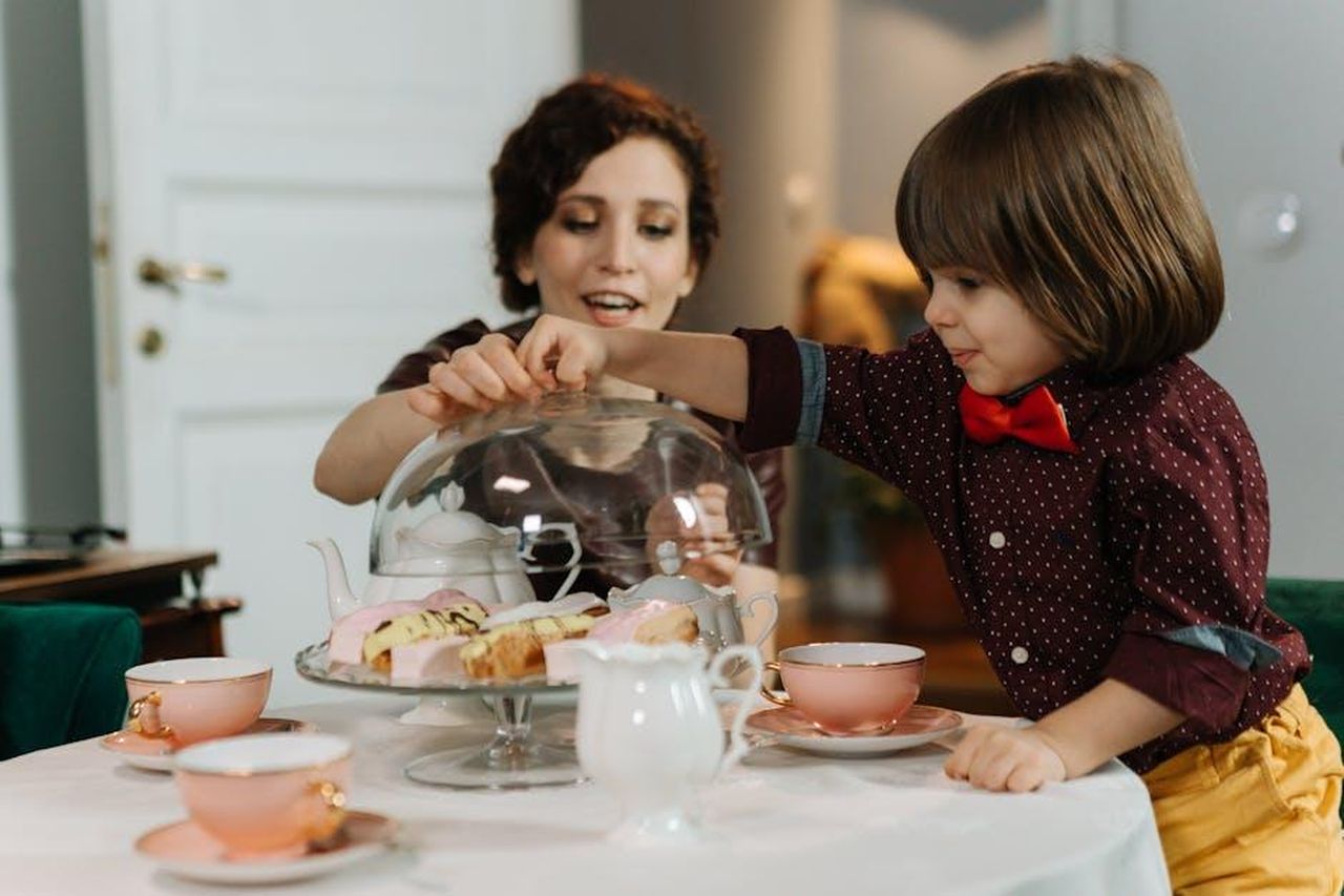Momenti_speciali_con_le_figlie_TEBnF1YN02 - Confidenze24 Source: cottonbro studio - pexels - A mother and child sharing tea and pastries at an indoor table, enhancing family moments.