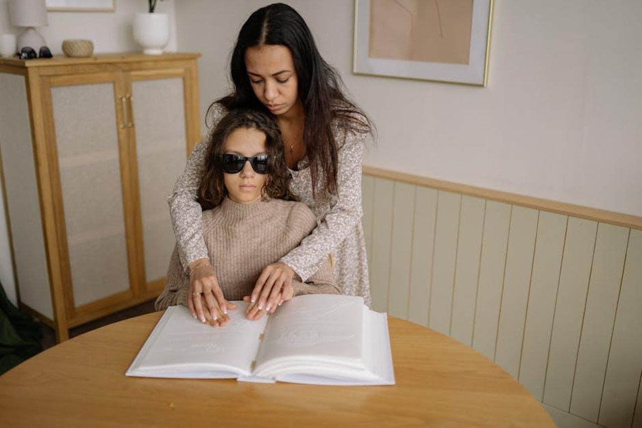Monica_e_Joey_si_sono_sposati_6VrdjlRmeY - Confidenze24 Source: Yan Krukau - pexels - Mother supports her visually impaired daughter reading Braille at home.