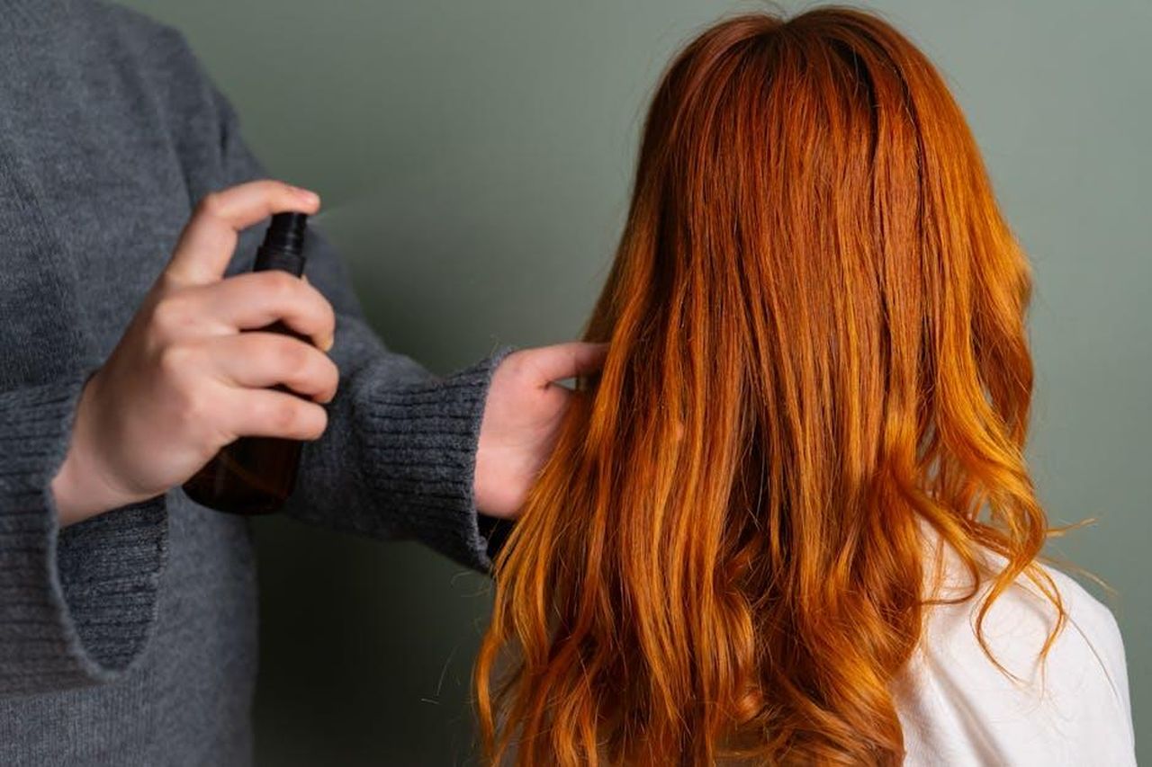 Moroccanoil_Luminous_Hairspray_Strong_tenuta_e_lucentezza_u74KkjAURy - Confidenze24 Source: Beyzanur K. - pexels - Close-up of hairdresser spraying hair product on long red hair.