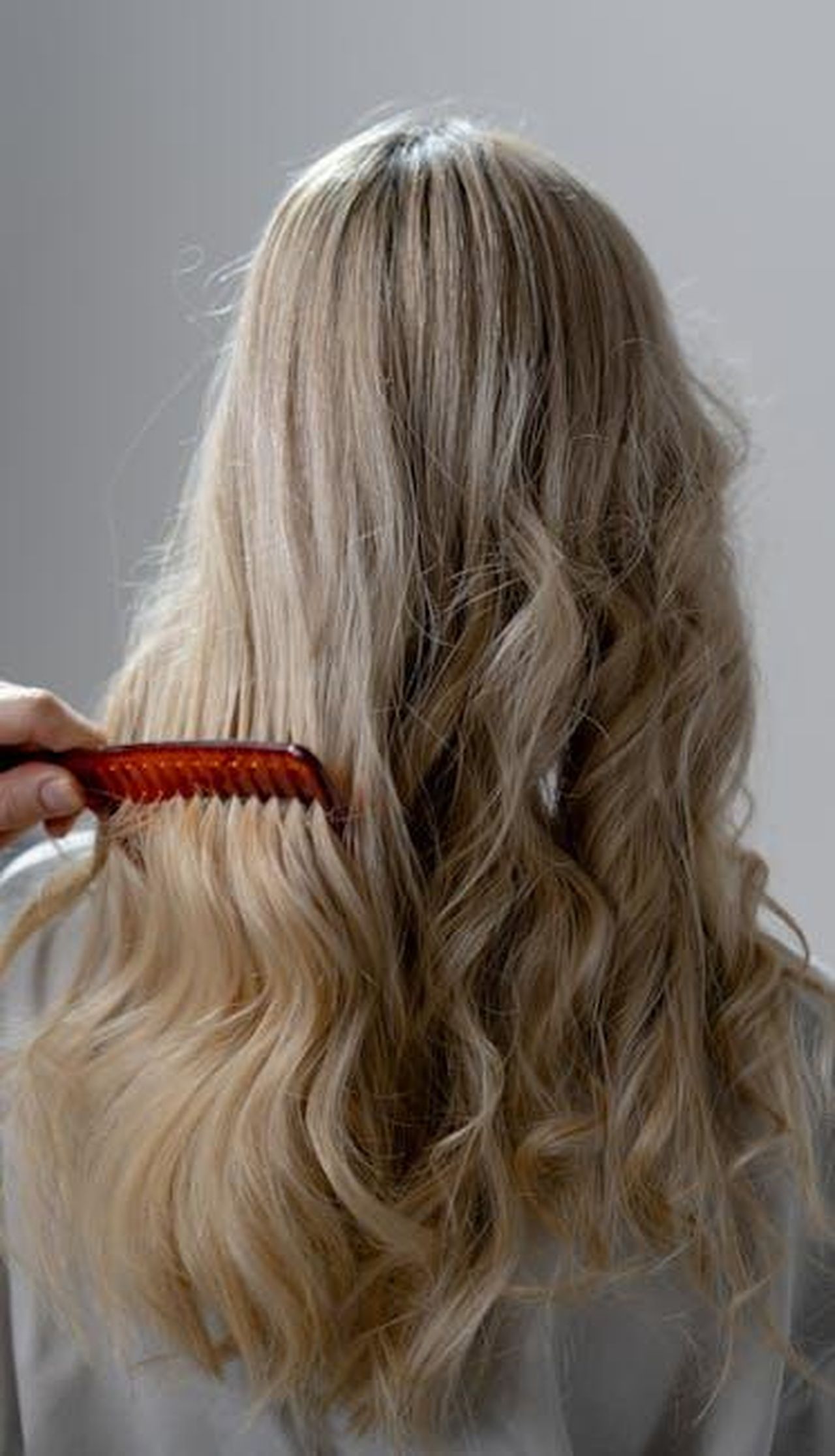 Moroccanoil_Treatment_Original_il_segreto_per_capelli_lucenti_lUEFoFgrtO - Confidenze24 Source: cottonbro studio - pexels - Back view of long blonde hair being combed into smooth curls with a red comb.