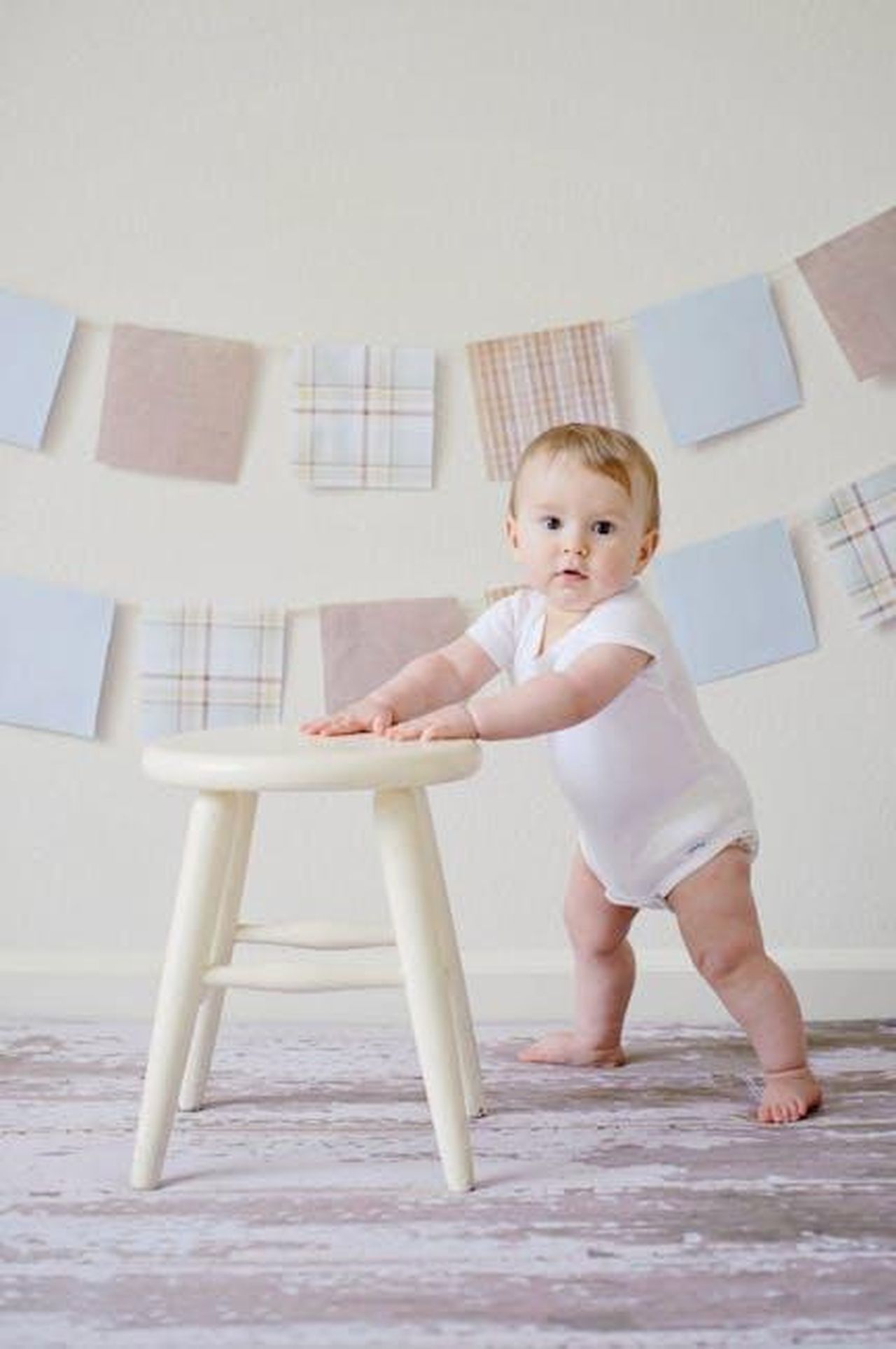 Nascita_della_figlia_Tallulah_1mNaqcWmUj - Confidenze24 Source: Pixabay - pexels - Cute baby standing by a stool indoors with a playful background.