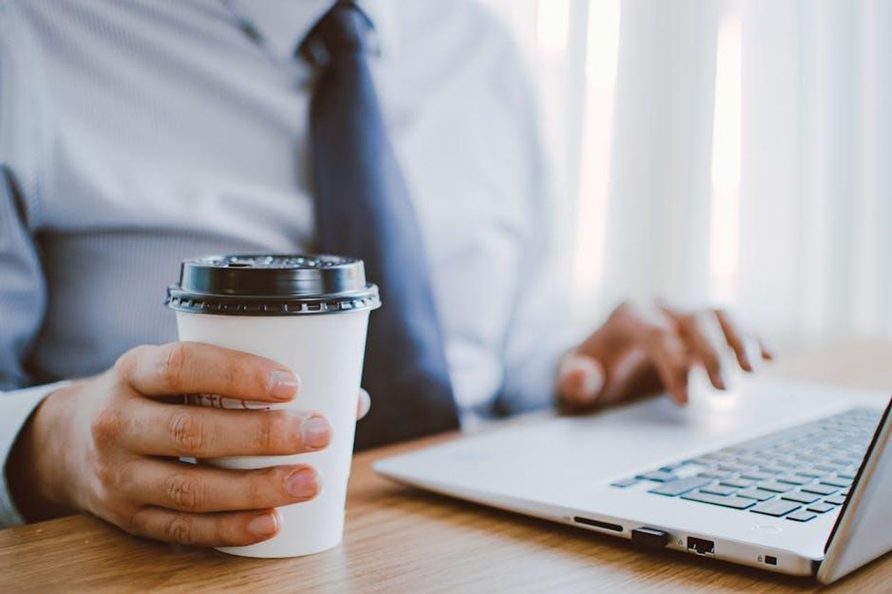 Navigare_le_questioni_di_marchio_con_American_Riviera_Orchard_XBIxcZwtGQ - Confidenze24 Source: Lisa from Pexels - pexels - Business professional working remotely, enjoying coffee while using a laptop indoors.