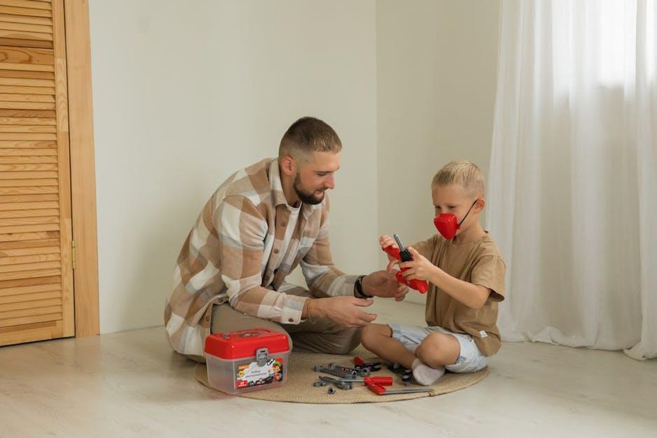 Noel_e_il_desiderio_di_avere_figli_NQh8yCwB3z - Confidenze24 Source: Polesie Toys - pexels - A father and son enjoy playing with a toy toolbox inside a cozy home setting, fostering creativity and bonding.