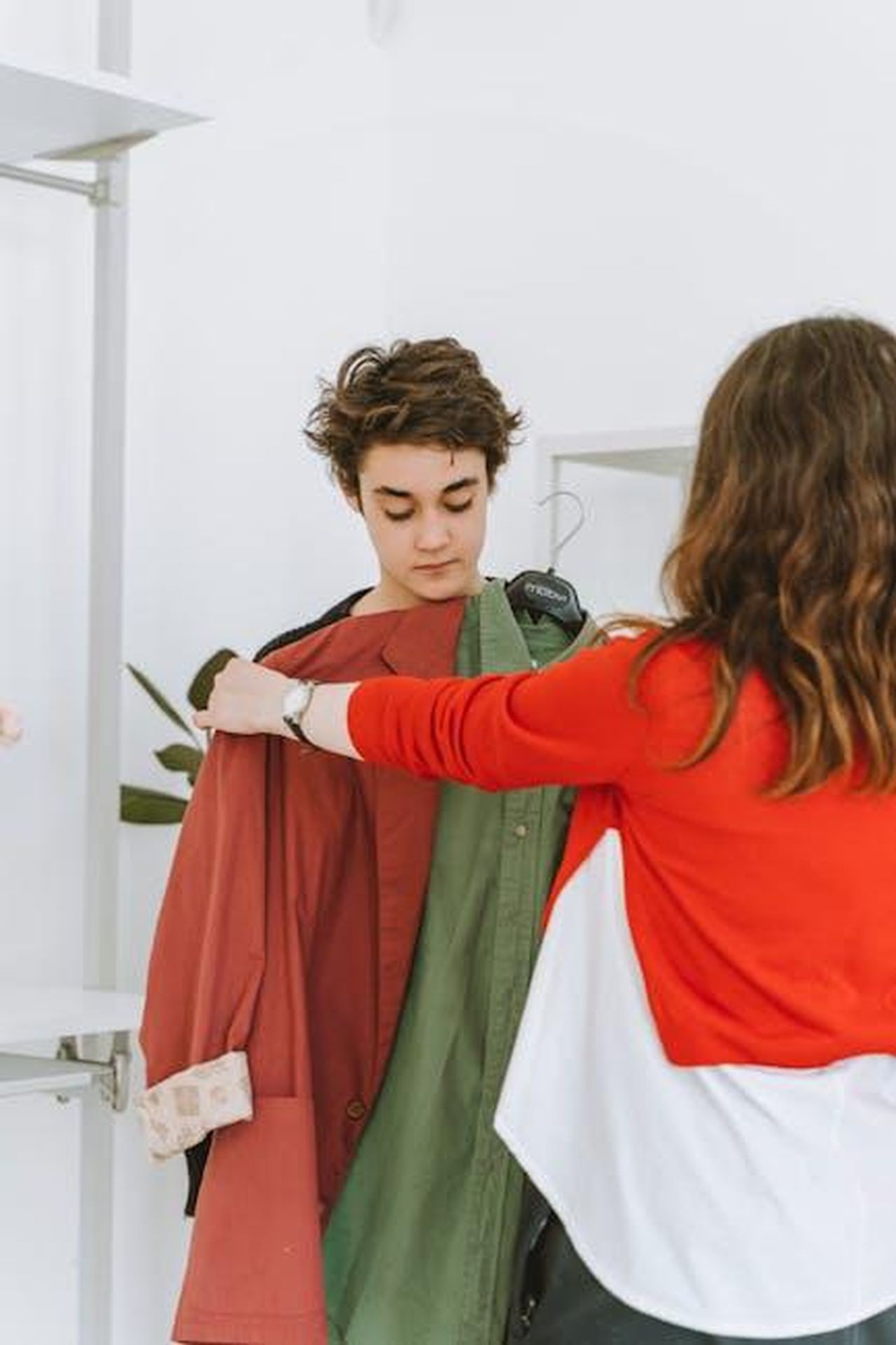 Non_ho_mai_avuto_quellurgenza_RFaWfKxEDh - Confidenze24 Source: Anastasia Shuraeva - pexels - A mother assists her teenage son in selecting clothing in an indoor store setting.