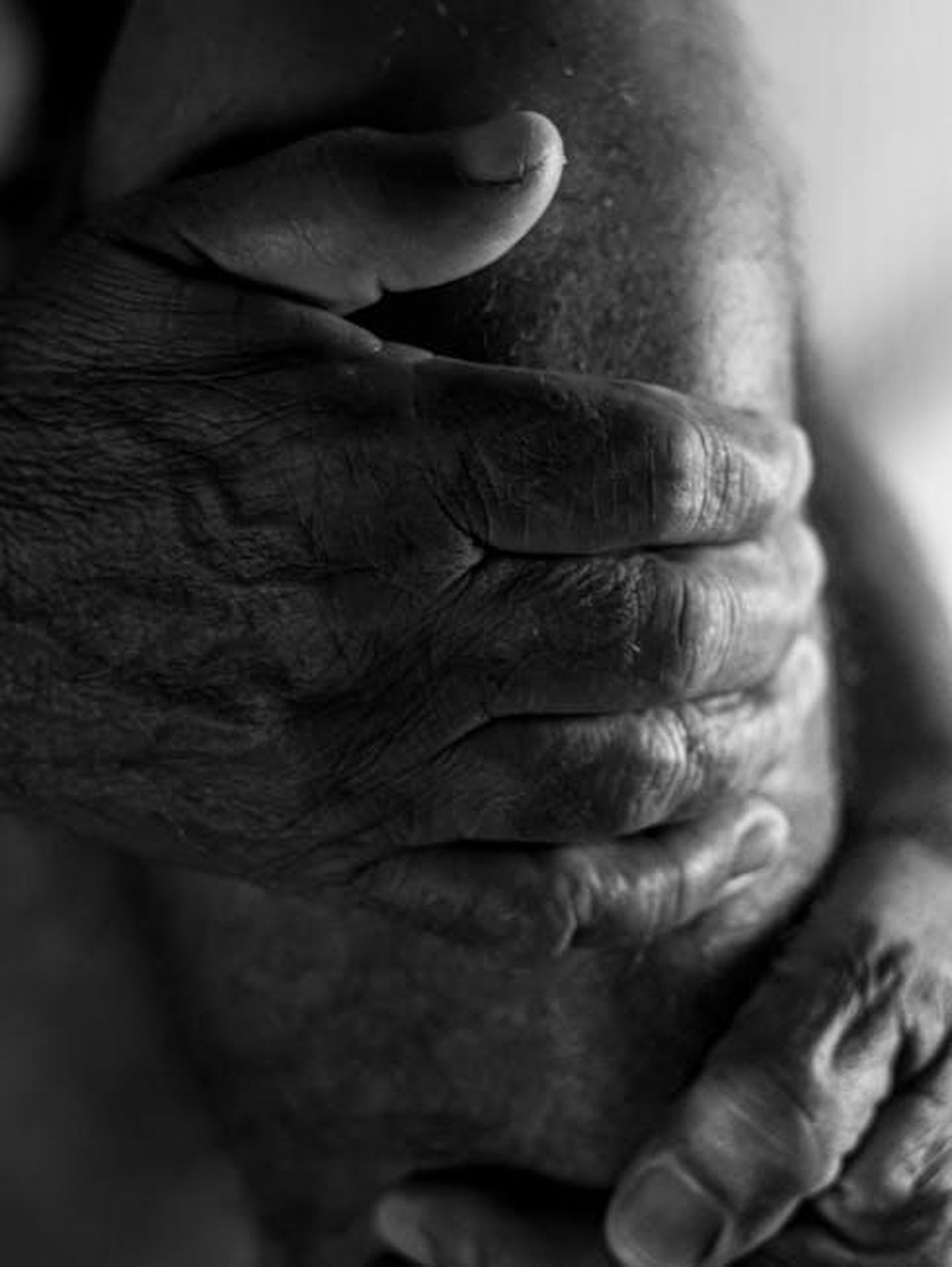 Non_sono_soli_yMa19dVwdC - Confidenze24 Source: Αλεξανδρος Μαμουνης - pexels - Close-up of elderly hands gripping a knee, emphasizing age and texture.