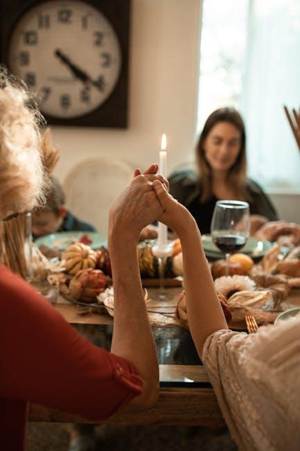 Non_vede_lora_di_tornare_a_casa_llBHVJVOMy - Confidenze24 Source: RDNE Stock project - pexels - A family holding hands in prayer before a Thanksgiving dinner indoors with warm fall decor.