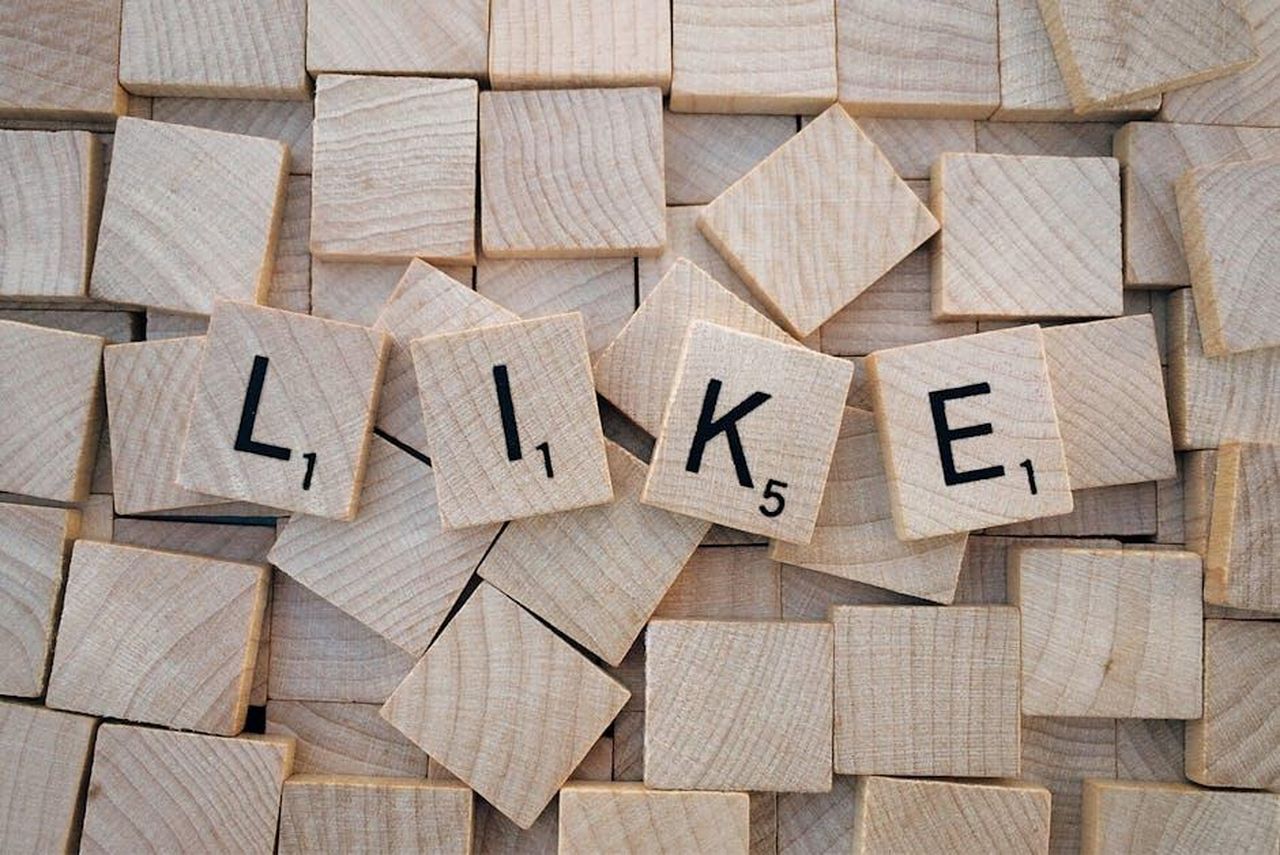 Non_vuole_sembrare_una_pushover_5y2SvltLDf - Confidenze24 Source: Pixabay - pexels - Top-down view of Scrabble tiles spelling 'LIKE' on a pile of blank wooden tiles.