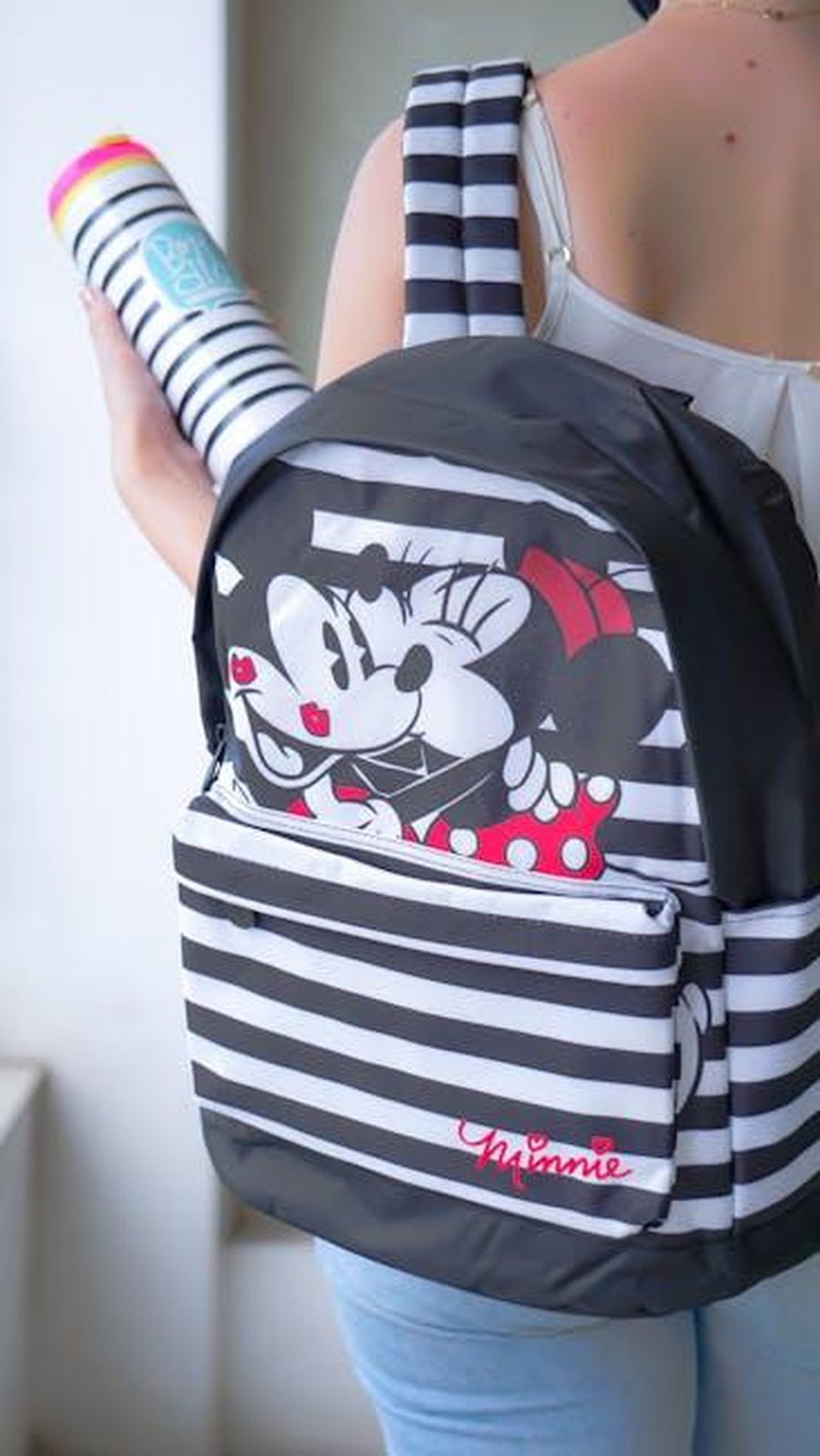 Offerte_imperdibili_su_borse_Disney_x_Kate_Spade_TxfMxnm80h - Confidenze24 Source: MOISES RIBEIRO - pexels - Close-up of a person carrying a striped backpack with an iconic cartoon character, showcasing vibrant design.