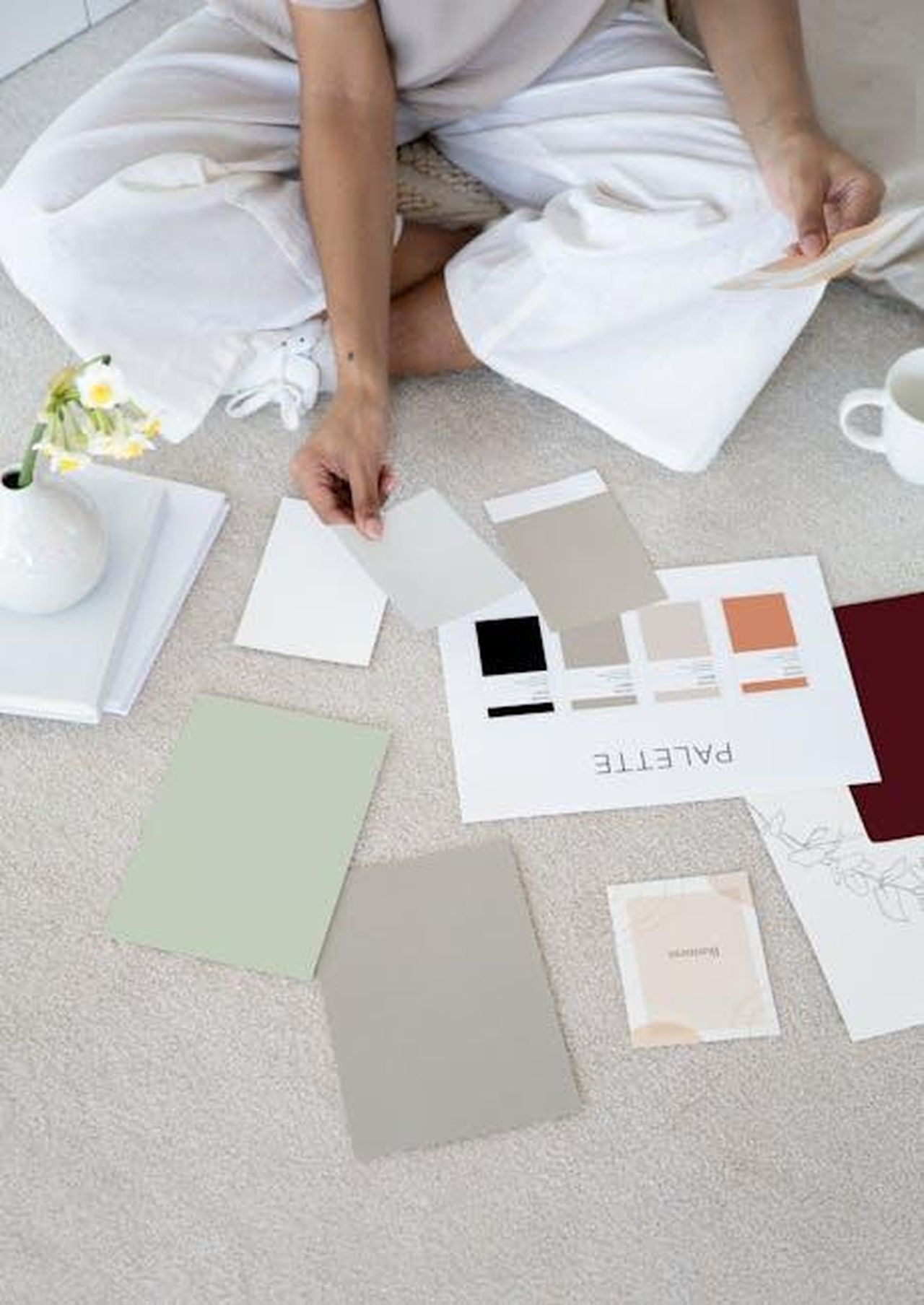 Offerte_speciali_su_altre_bambole_American_Girl_48mvmDRr6s - Confidenze24 Source: Anna Nekrashevich - pexels - Designer sits on carpet with color palettes and samples, planning creative project.