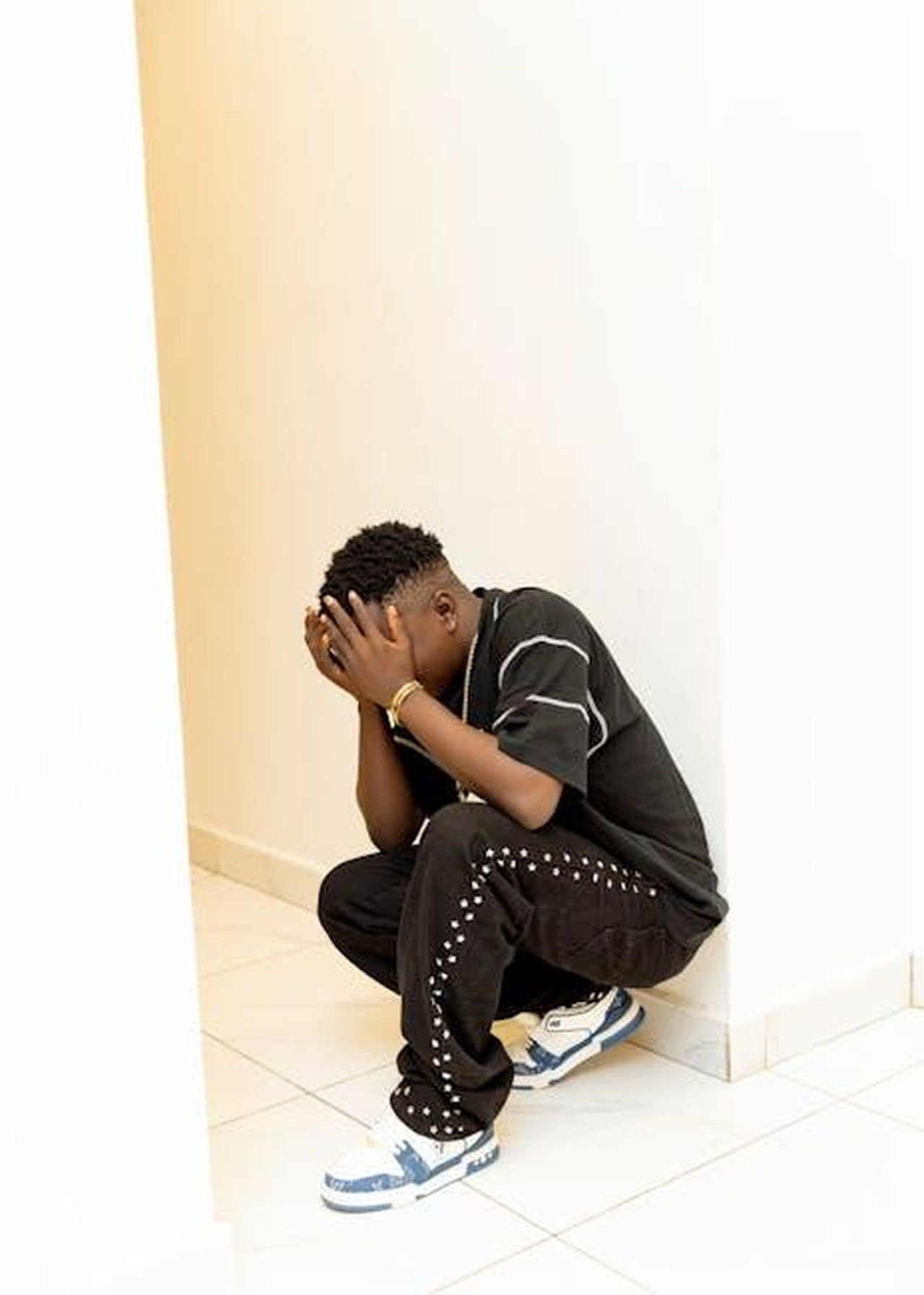 Opinione_lepisodio_della_soap_offre_unimportante_visione_sulla_salute_mentale_AFCyaBjmPC - Confidenze24 Source: Mustapha Damilola - pexels - A person squatting in light corner with hands on face, expressing stress or sadness.