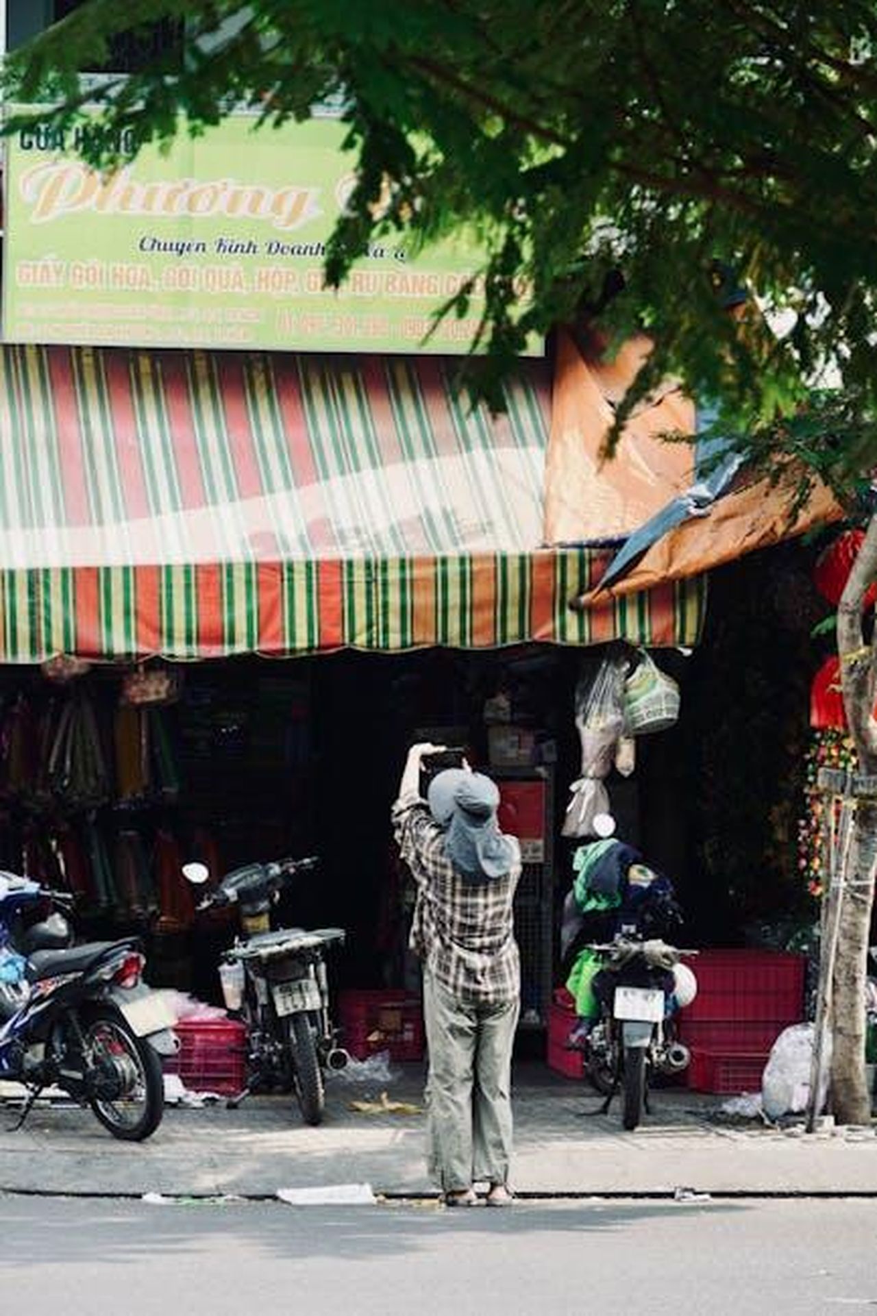 Opinioni_dei_clienti_4OjY2yTMZS - Confidenze24 Source: Tuan Vy - pexels - Person capturing a vibrant street market scene with motorbikes and colorful shopfront.