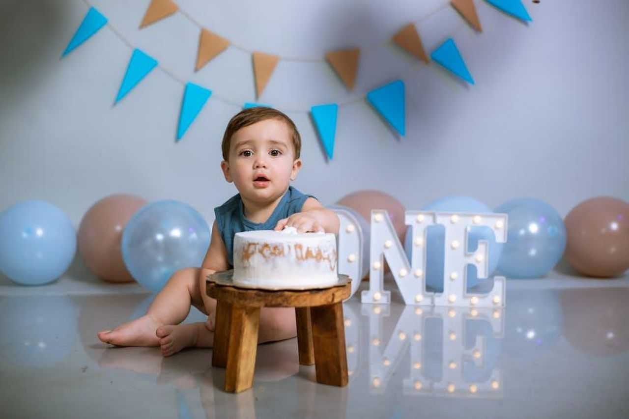 Oti_riflette_sul_suo_io_di_12_anni_HjvWBK02lt - Confidenze24 Source: Norman Milwood - pexels - Baby celebrating first birthday with cake, balloons, and decorations.