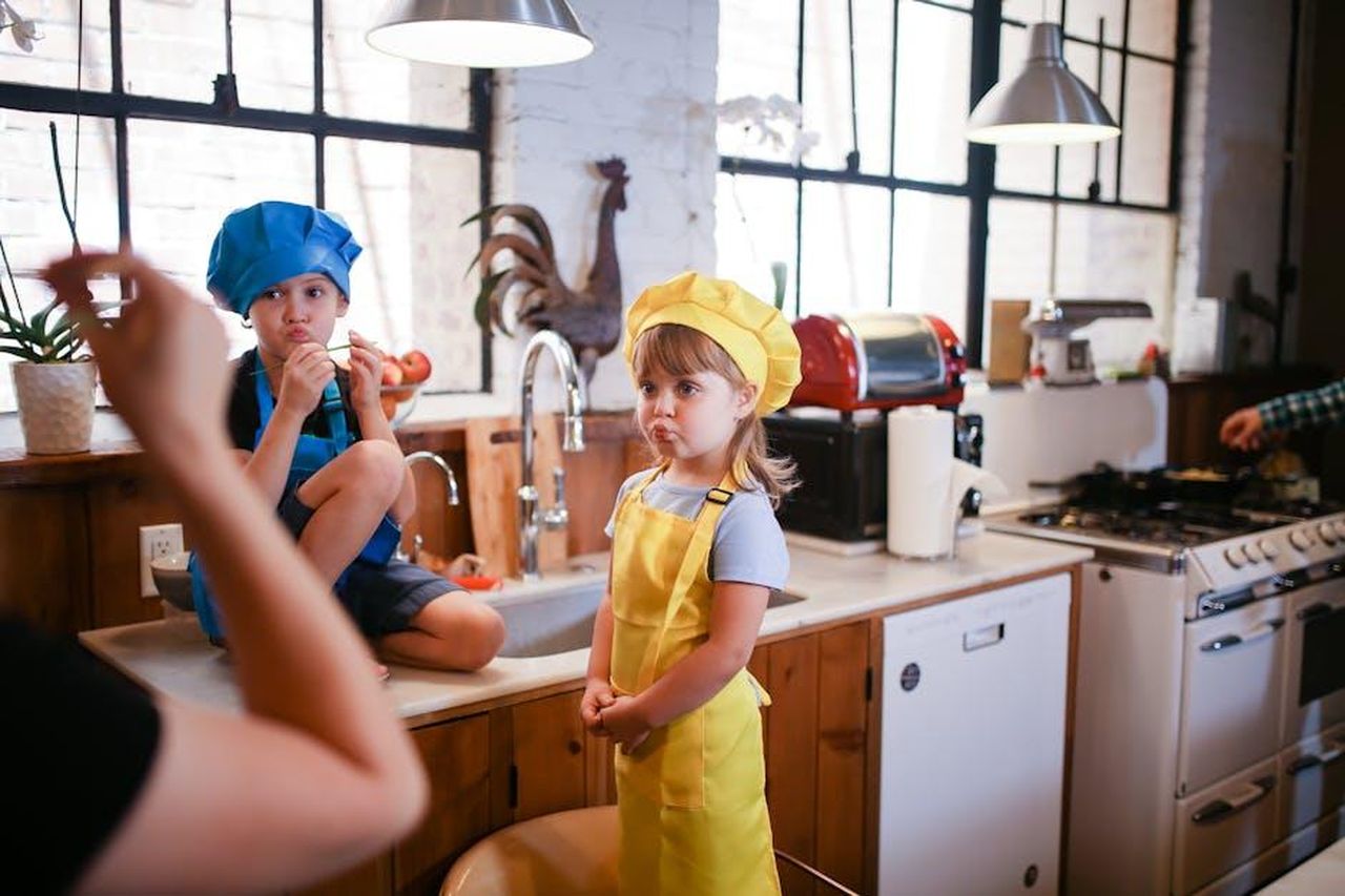 Pamela_Anderson_e_il_suo_programma_di_cucina_rep2MMBoO7 - Confidenze24 Source: RDNE Stock project - pexels - Two kids in colorful chef hats enjoy a playful cooking session in a cozy kitchen setting.