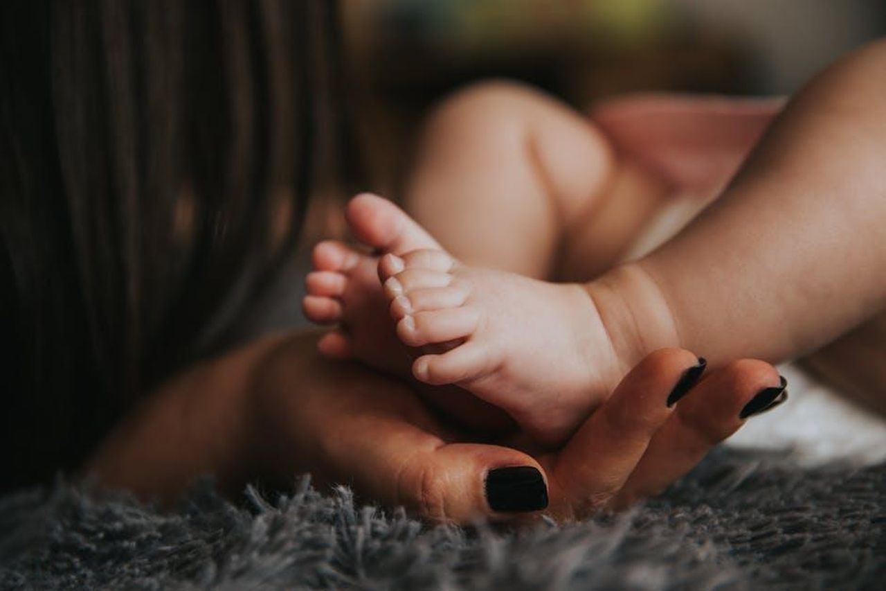 Patrick_ha_parlato_affettuosamente_di_sua_madre_nel_corso_degli_anni_kGbz5H6gZu - Confidenze24 Source: Pixabay - pexels - Close-up of a mother's hand gently holding her baby's tiny feet, symbolizing warmth and affection.