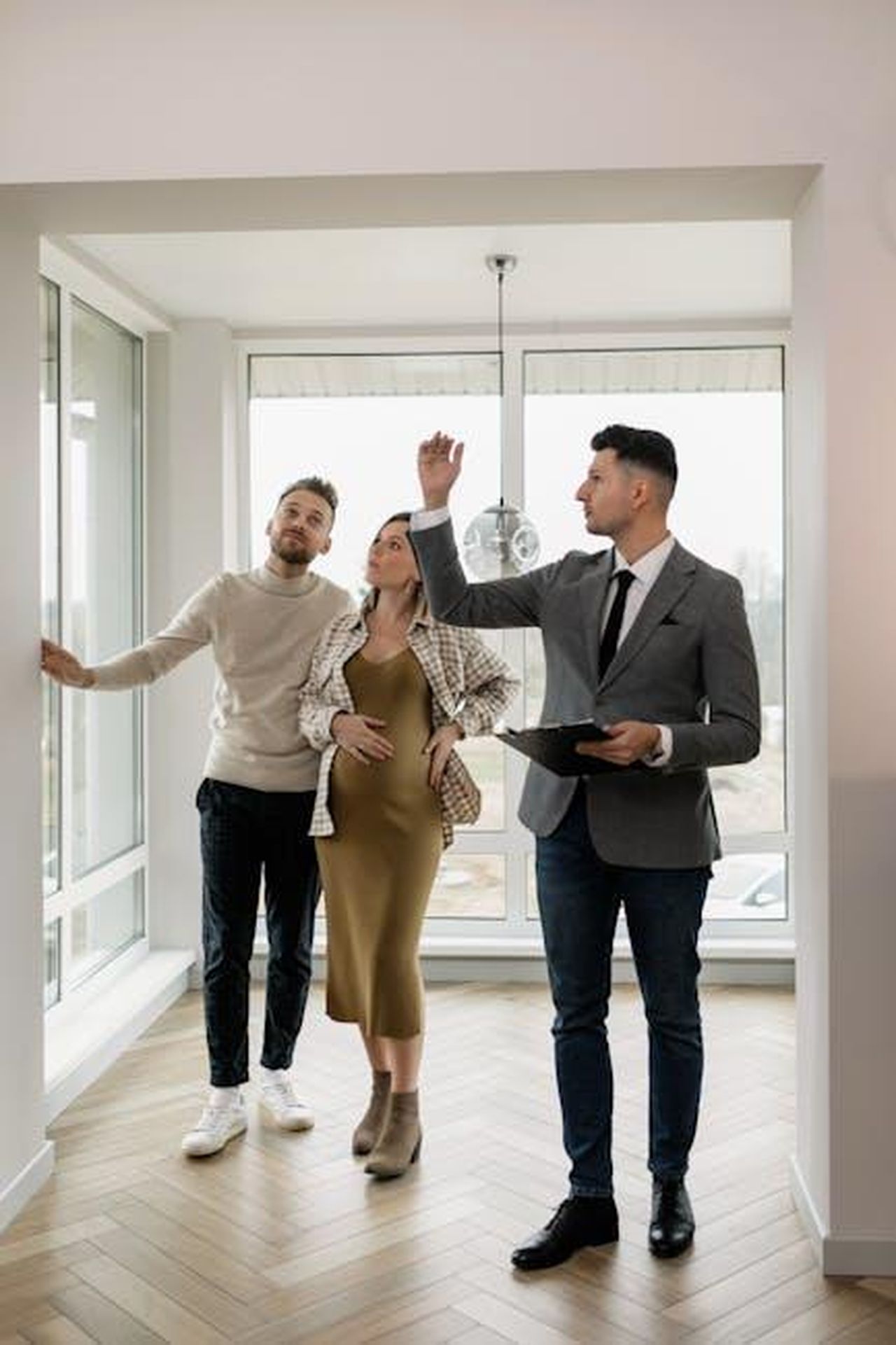 Perch_Mark_e_Michelle_hanno_aspettato_per_avere_un_bambino_E4ulBKmOF3 - Confidenze24 Source: Alena Darmel - pexels - A couple tours a modern home with a real estate agent, exploring their potential new living space.