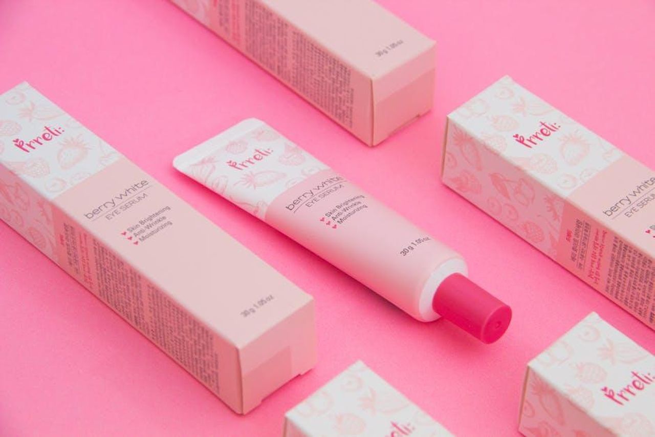 Perch_utilizzare_una_crema_contorno_occhi_j7Y7xaVeW8 - Confidenze24 Source: Ray Piedra - pexels - Pink-themed flat lay of berry-white eye serum with packaging.