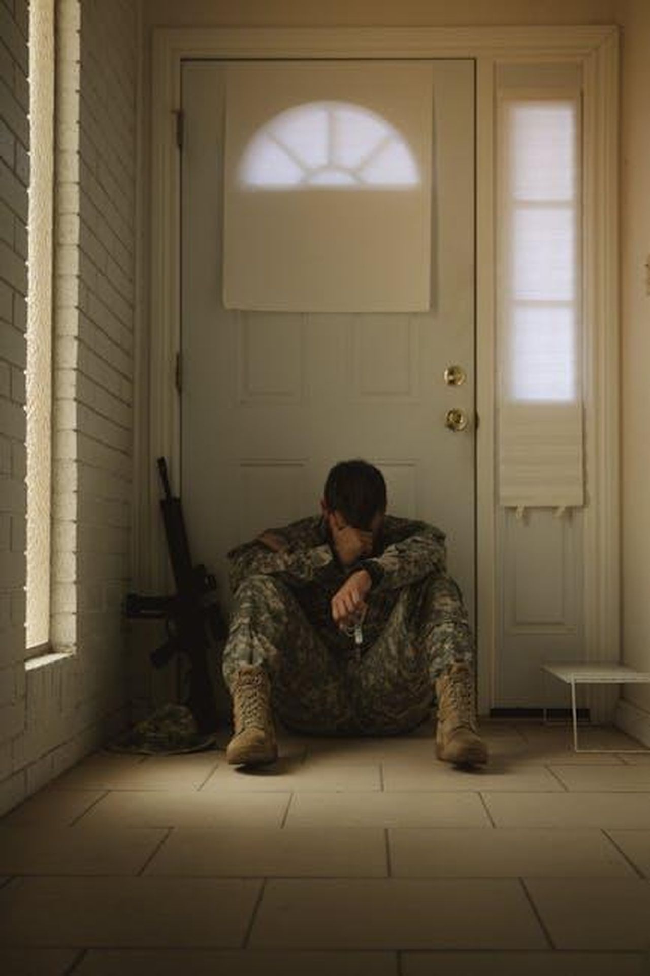 Perdita_dellOscar_e_tristezza_visibile_6AYhz3eTMN - Confidenze24 Source: Lance Reis - pexels - A solitary soldier in uniform sitting by a door, reflecting mood.